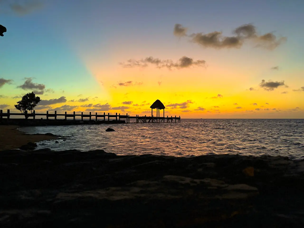 Sunset over the dock and palapa at Pristine Bay.