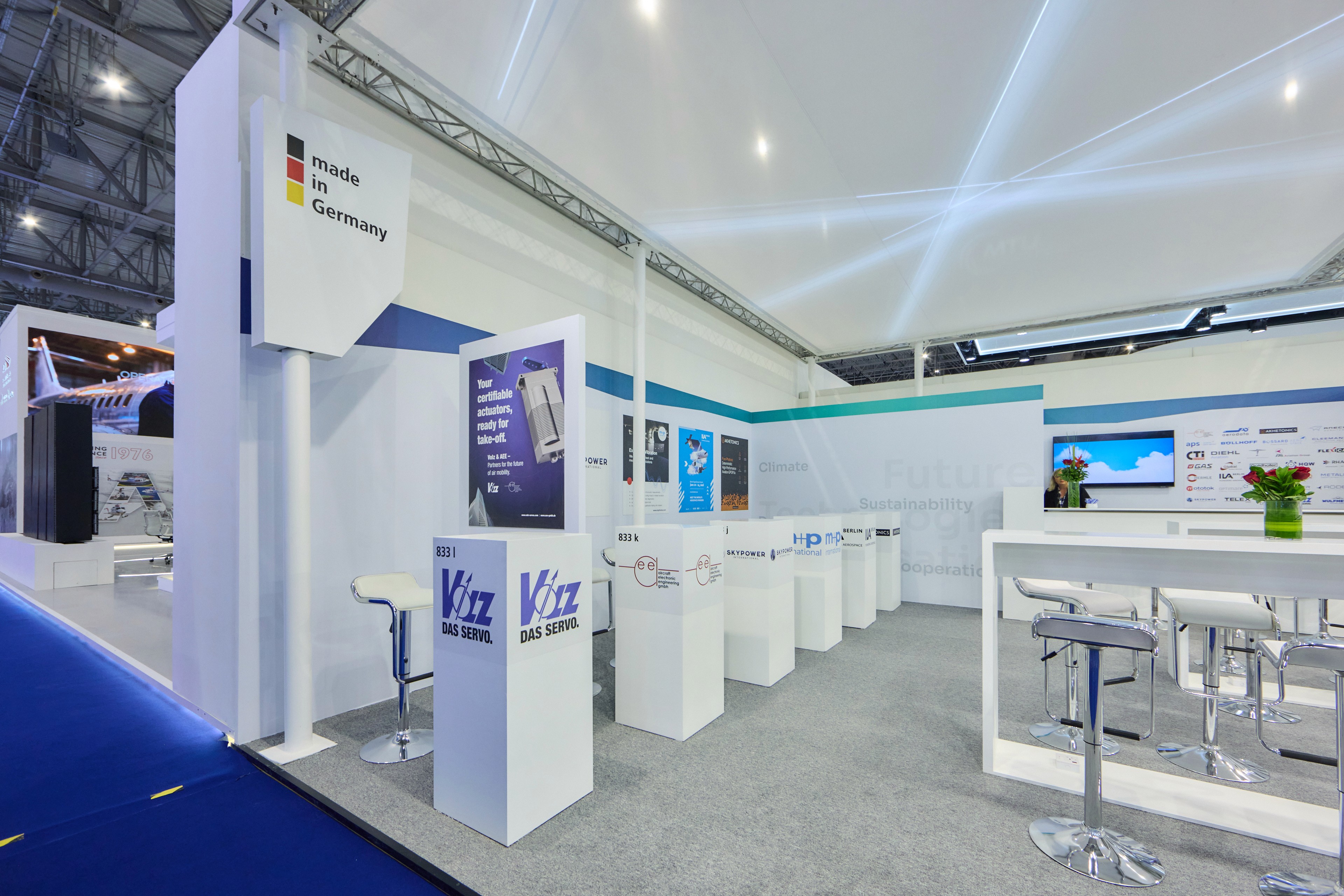 A view of an exhibition hall showing various trade fair stands, including those for Volz and AEE.