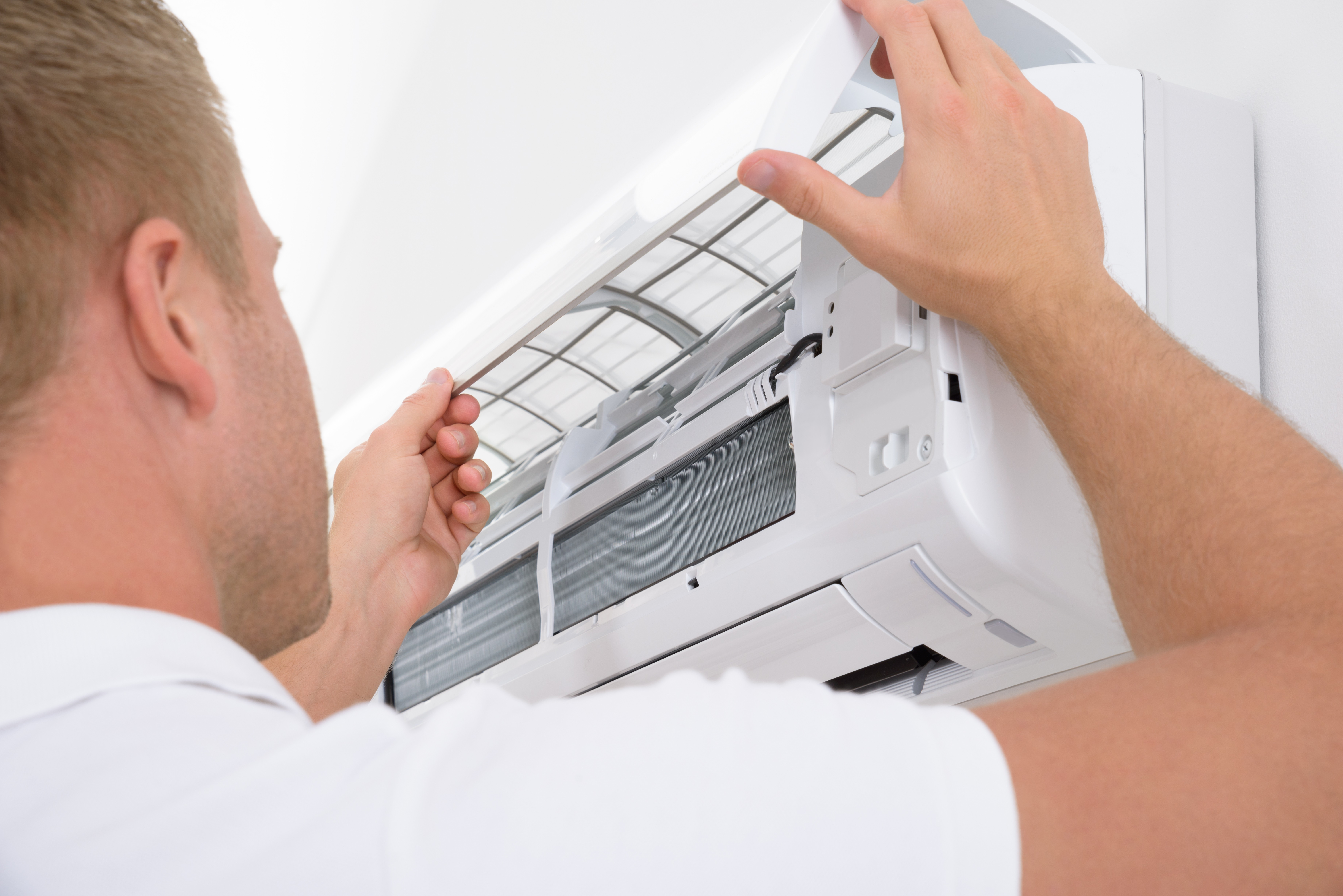 An engineer inspecting an air conditioning unit