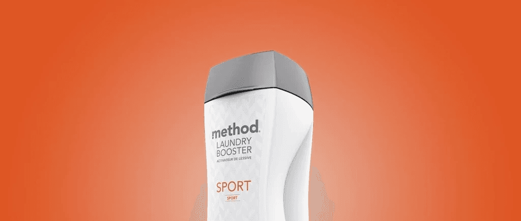 White laundry booster bottle with an orange label and a curved side recess, angled against an orange background