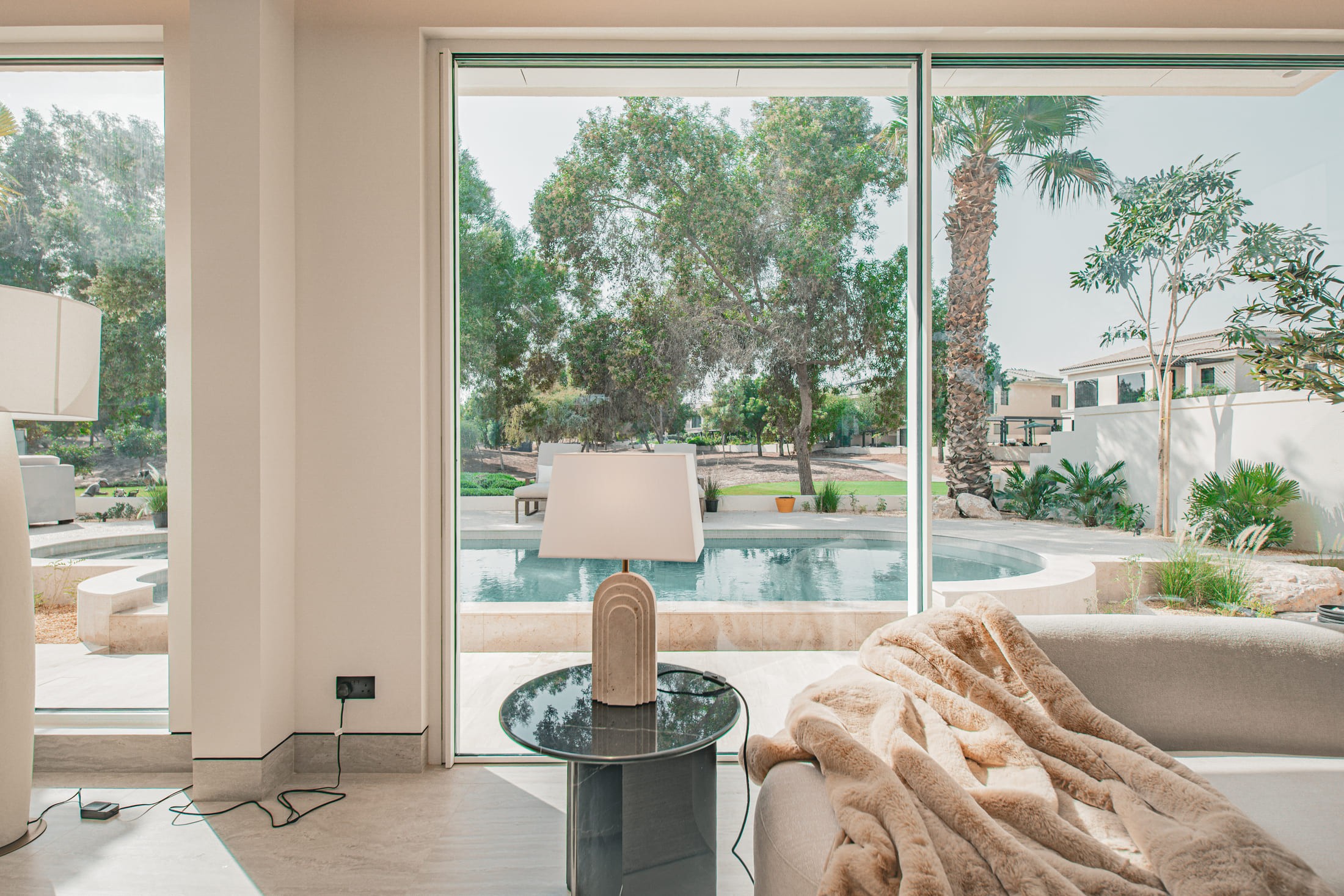 Image of a large villa with big glass windows and a pool 