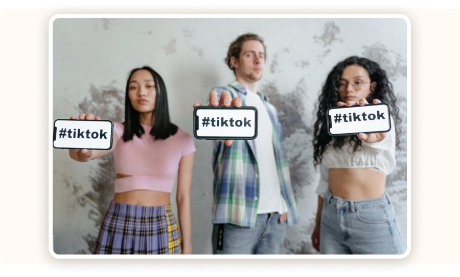 People holding phones displaying the #tiktok hashtag
