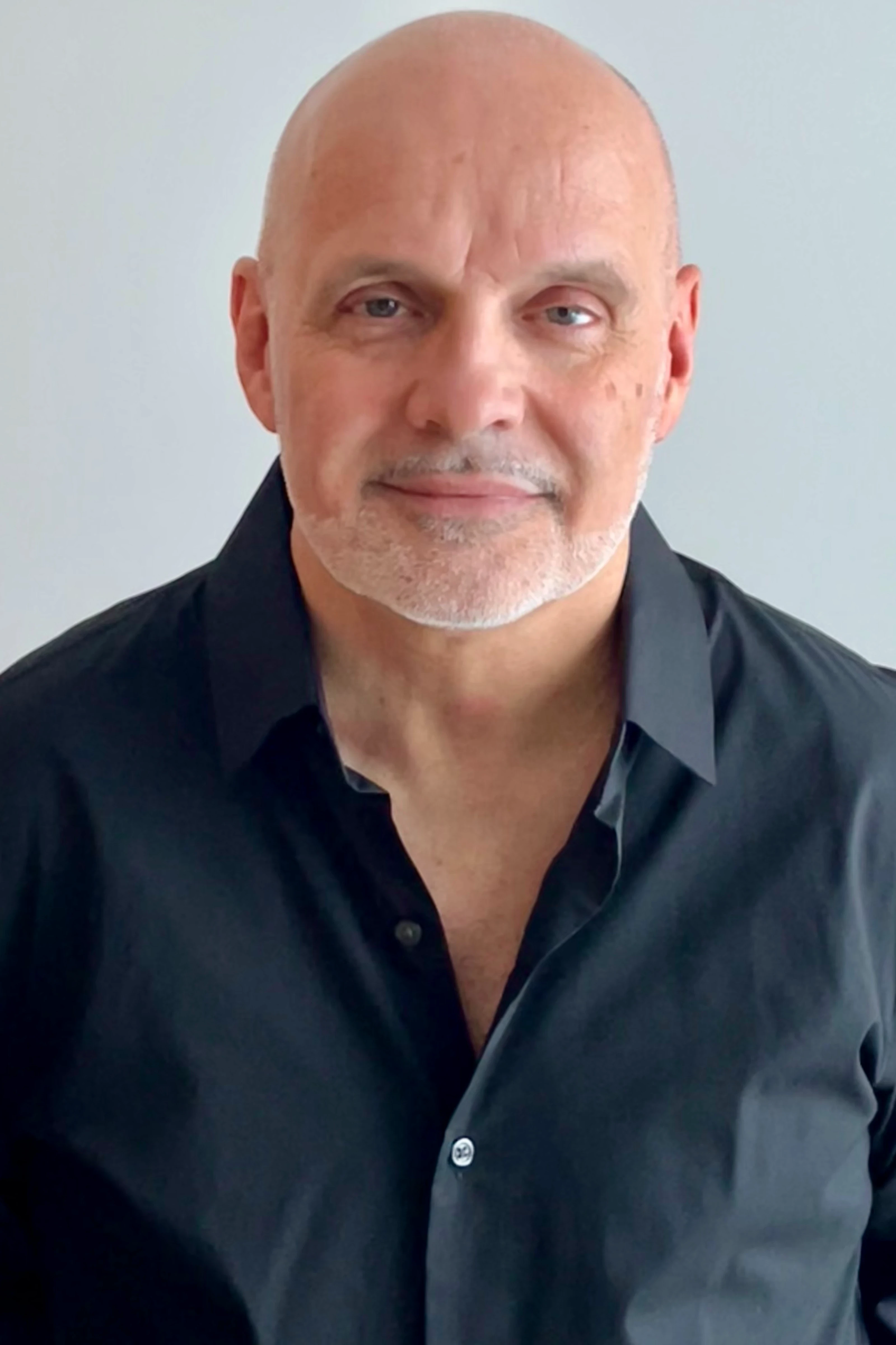Portrait of Stéphane Paquet wearing a black shirt, facing the camera against a light background.