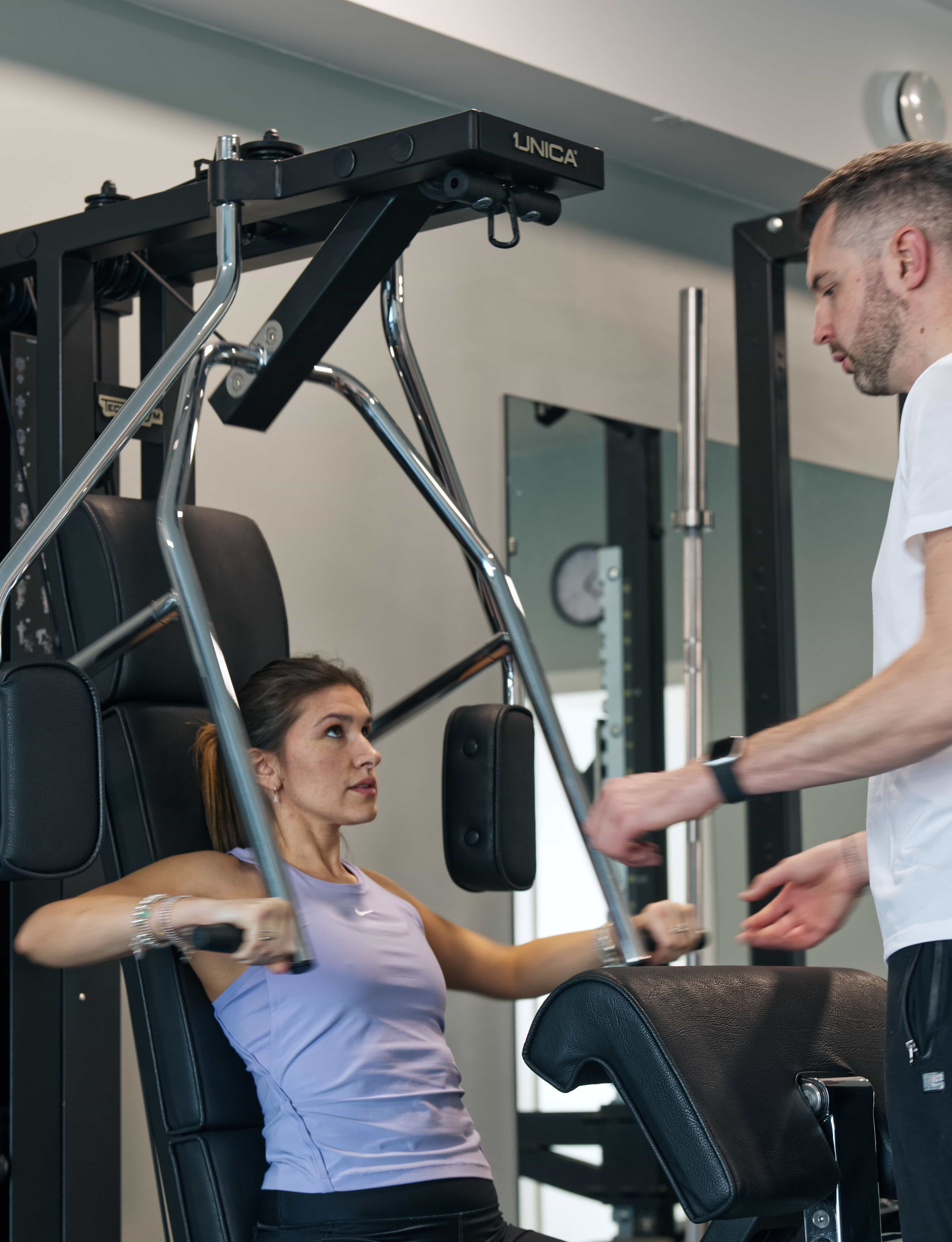 Young person with short, tousled blonde hair wearing an oversized, vibrant orange turtleneck sweater against a soft grey background, conveying a cool, modern look.
