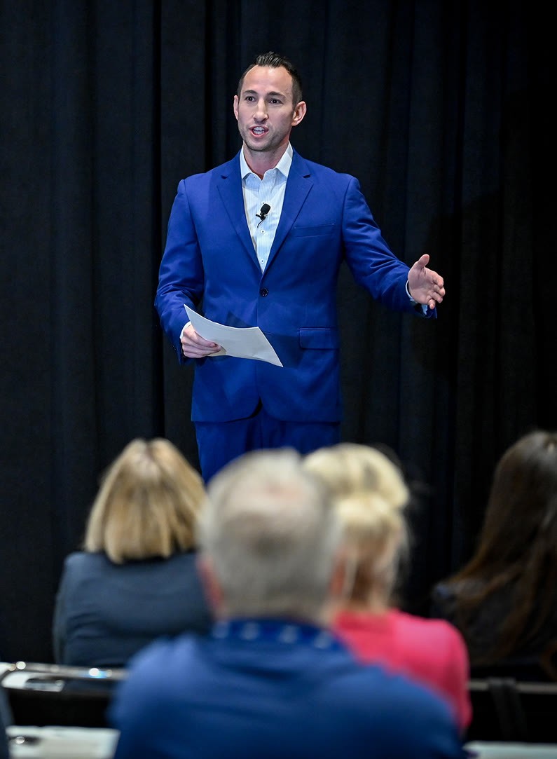 Brandon speaking to an audience at a conference