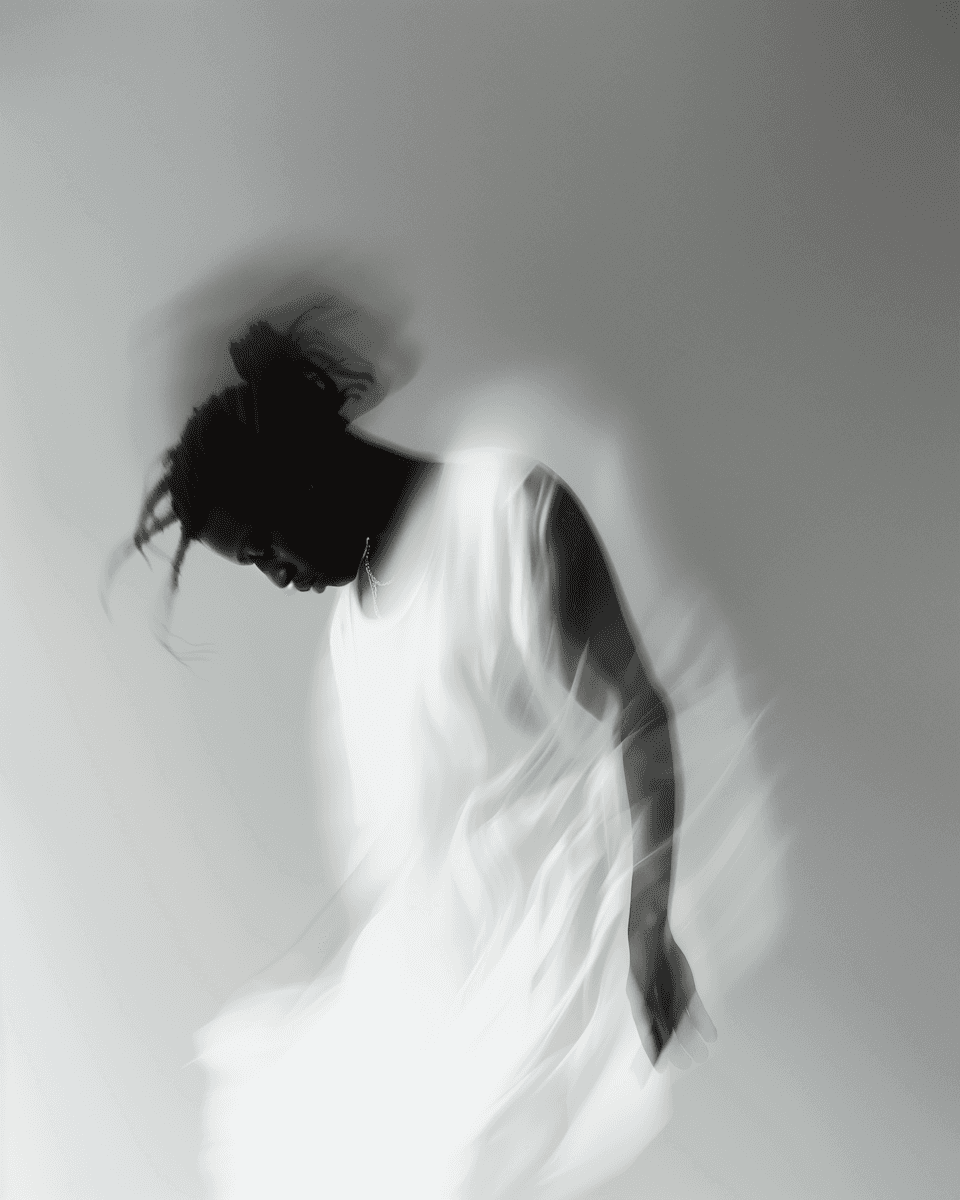 A silhouette of a figure in a flowing garment, appearing to bow or lean forward against a light background.