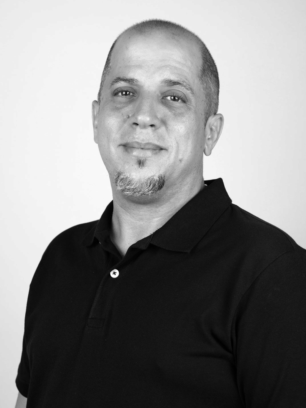 Retrato de hombre rapado con perilla y camisa negra