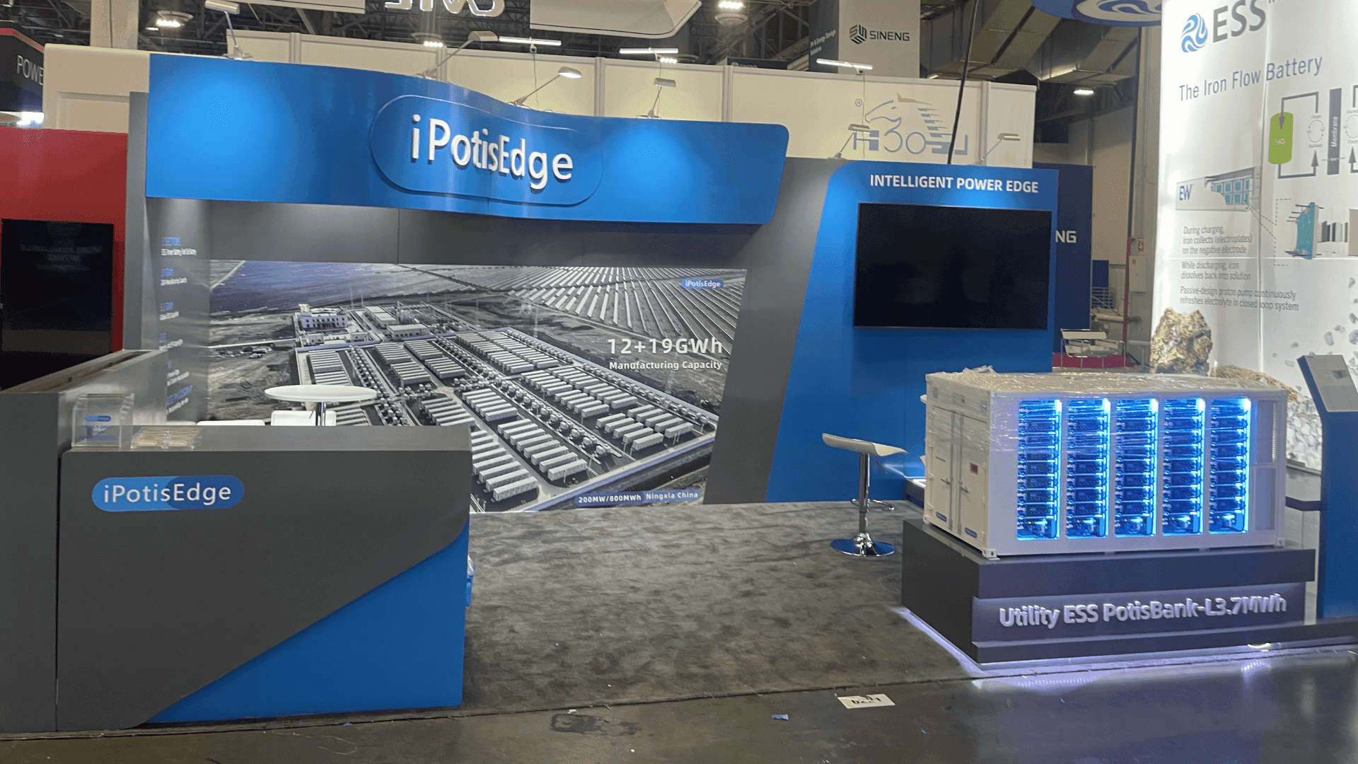 IpstisEdge RE+ 2023 10x20 utility ESS booth in Las Vegas with blue energy storage display, manufacturing capacity graphics, and reception counter