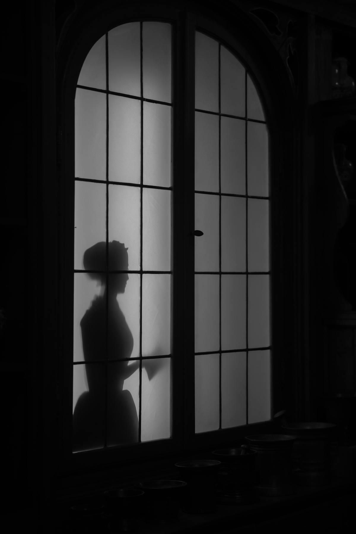 Mysterious silhouette of a woman behind frosted glass