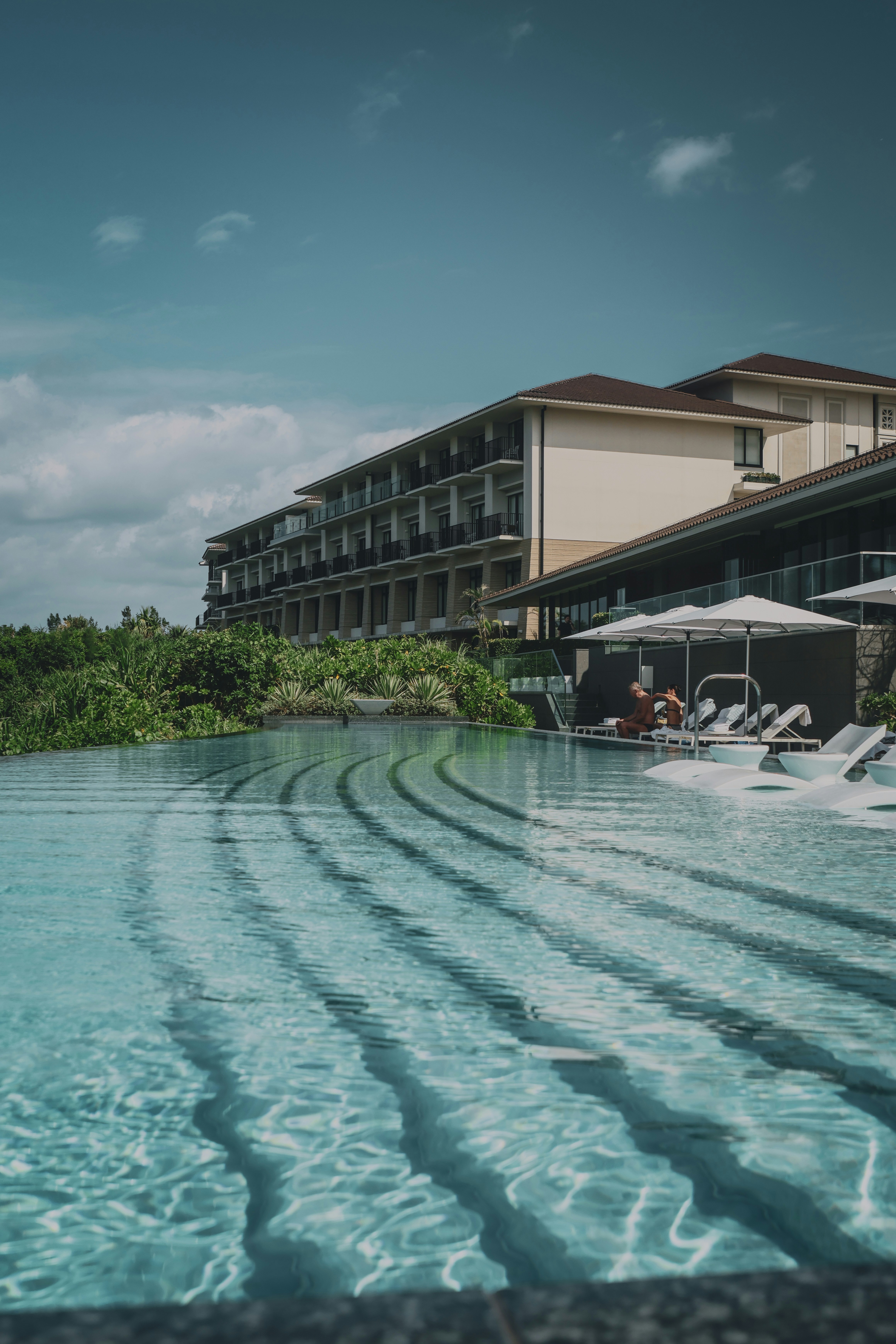 A large swimming pool with lounge chairs and umbrellas