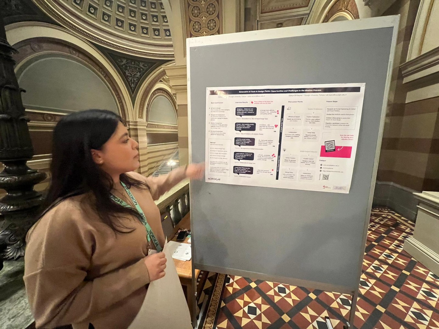 A woman presenting a poster about generative AI at the NordiCHI conference.