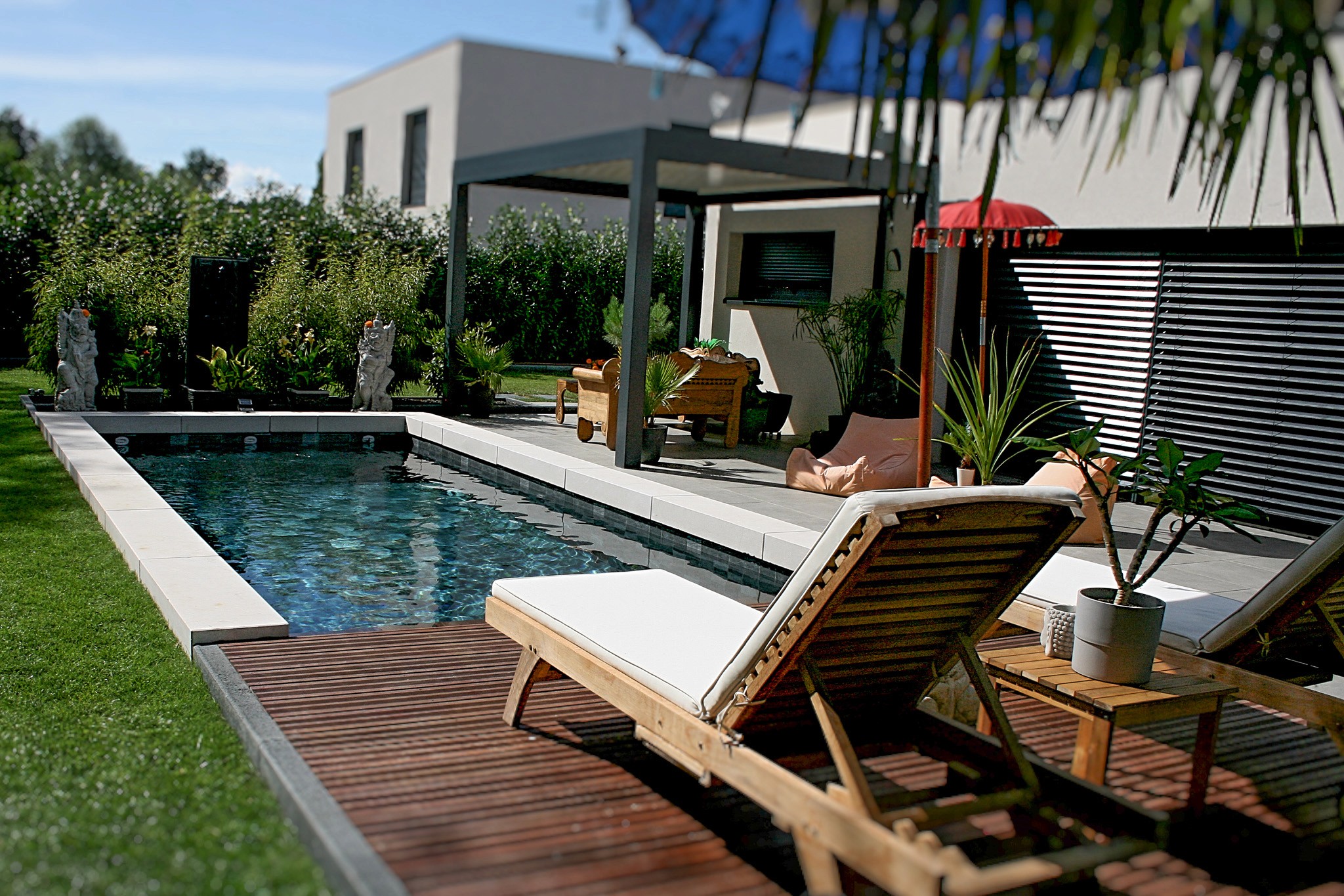 Piscine sur-mesure avec terrasse en bois et pergola moderne, réalisée par Acqua Terra dans le Haut-Rhin