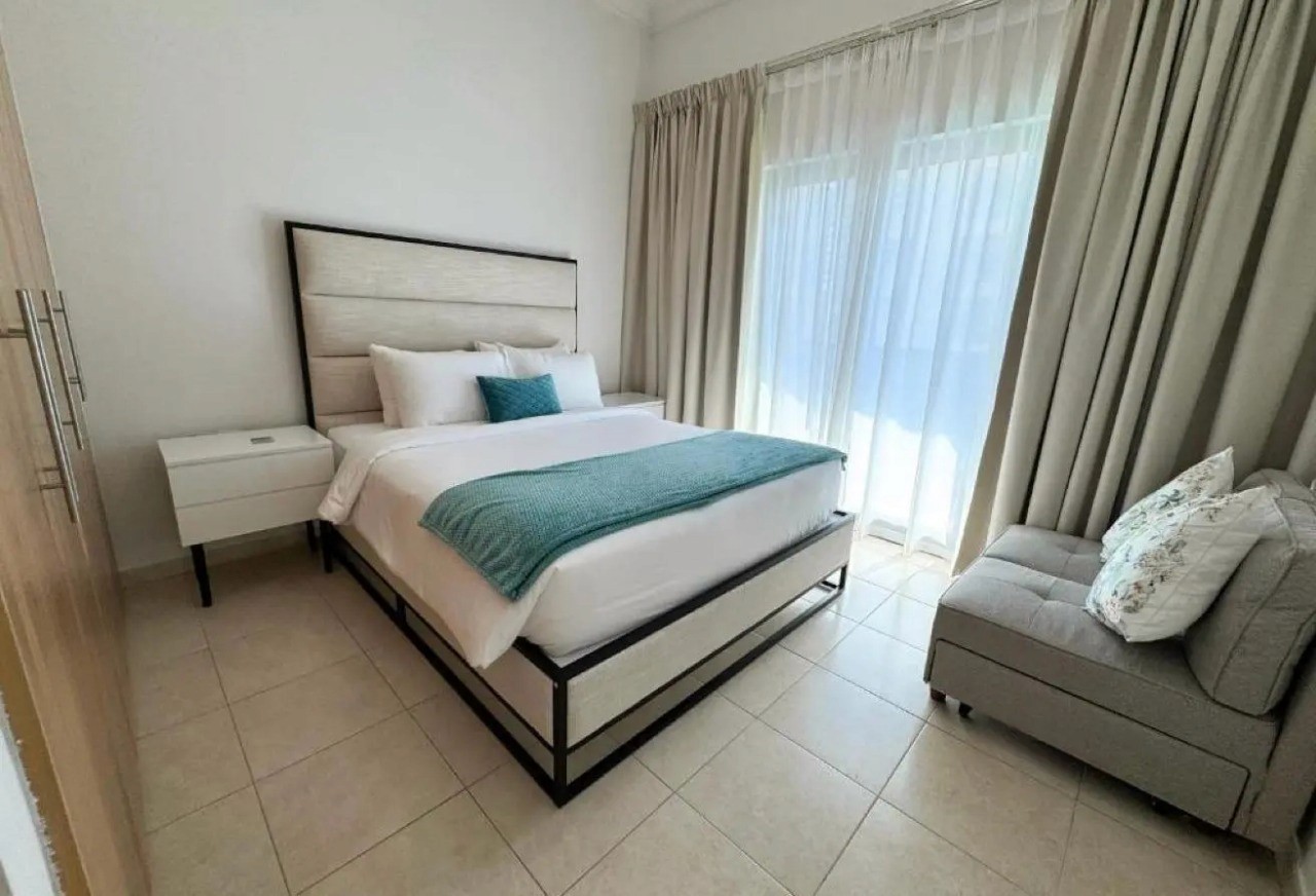 Spacious and modern bedroom interior with floor-to-ceiling windows in a Dubai Marina luxury apartment.