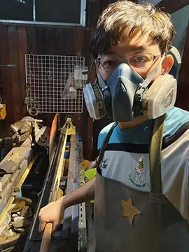 sunny akani wearing a protective mask while making snooker cues