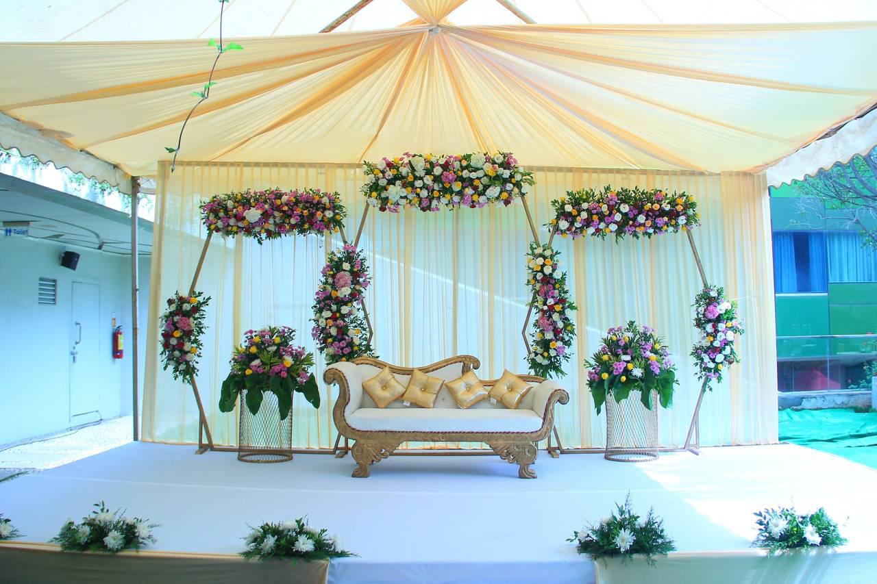 Modern indoor space with large glass doors, lush greenery, and a cozy seating area visible beyond.