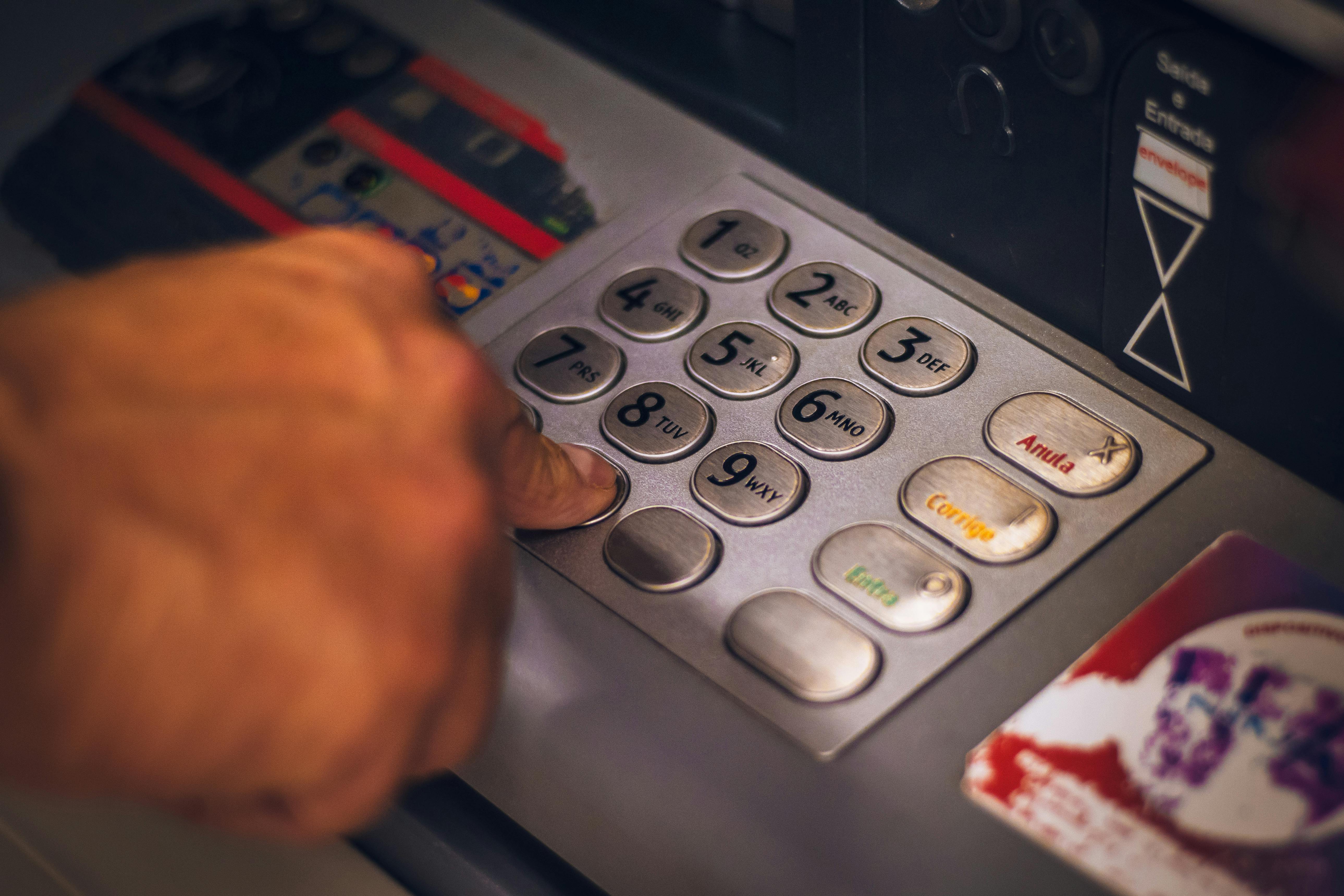 Close-up of a person entering a PIN code on an ATM keypad