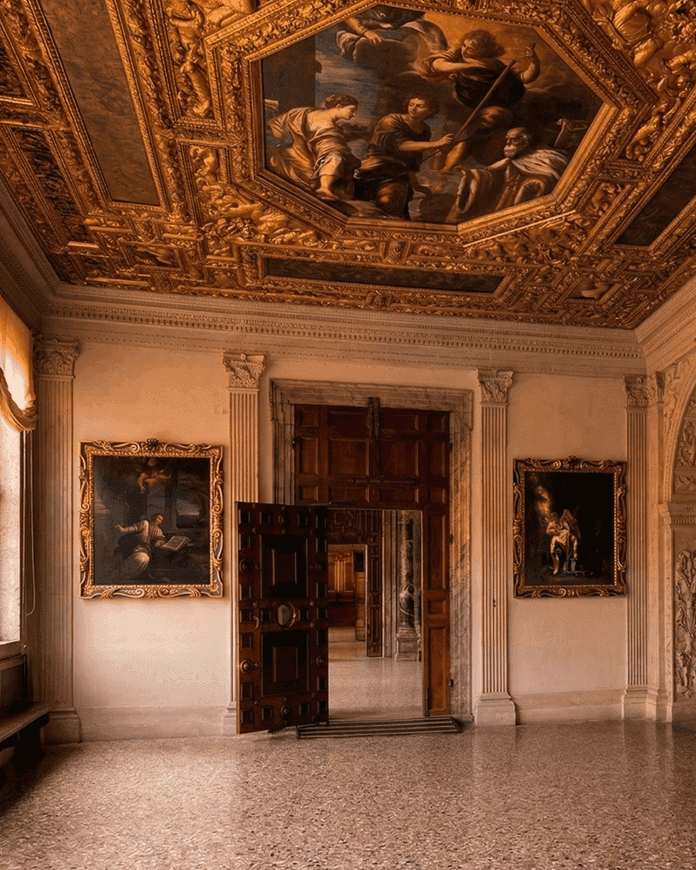 Интерьер зала Дворца дожей в Венеции с резной дверью и картинами эпохи Ренессанса