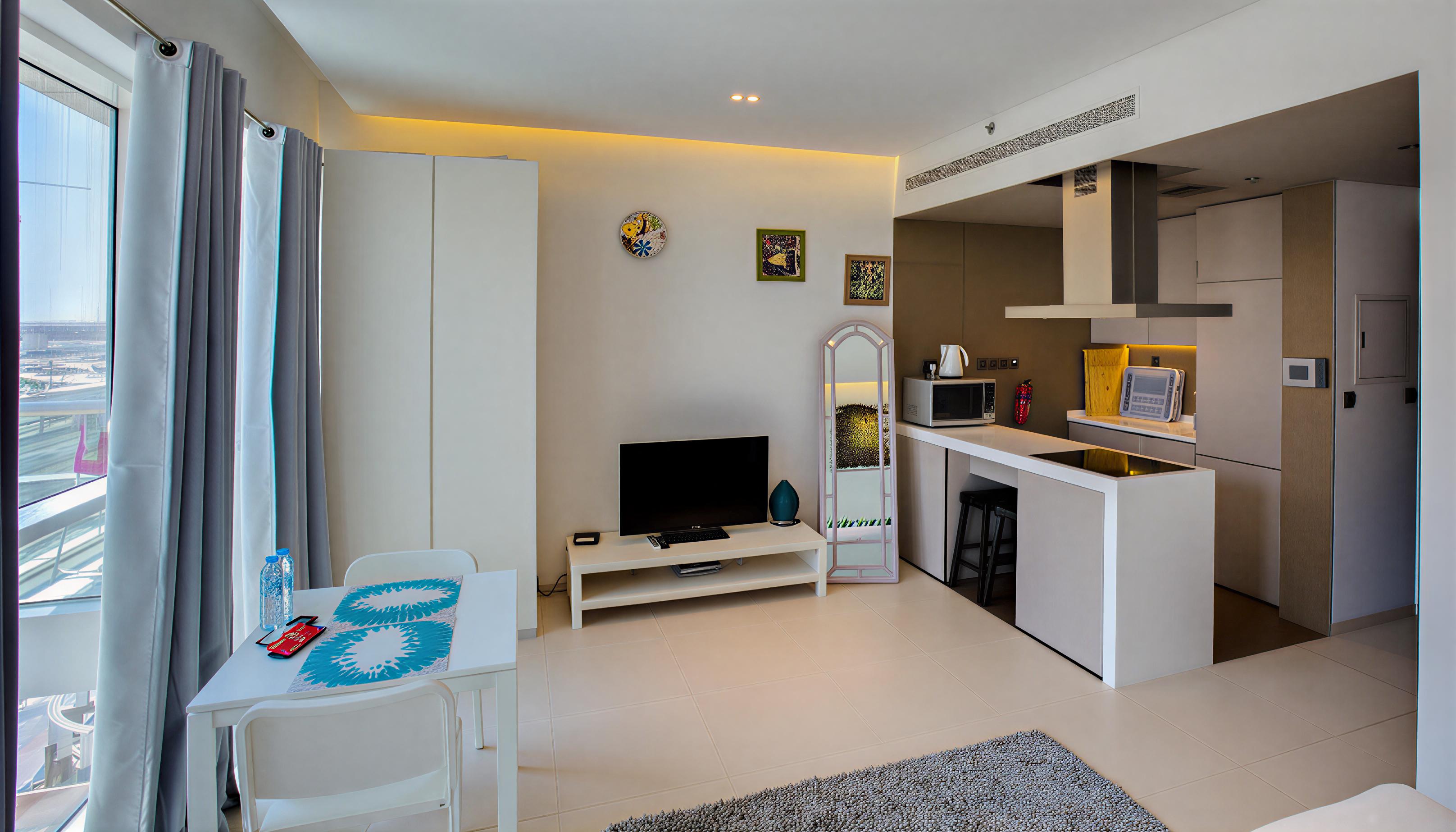 Interior view of a small apartment with a kitchen and living room in West Avenue Tower.