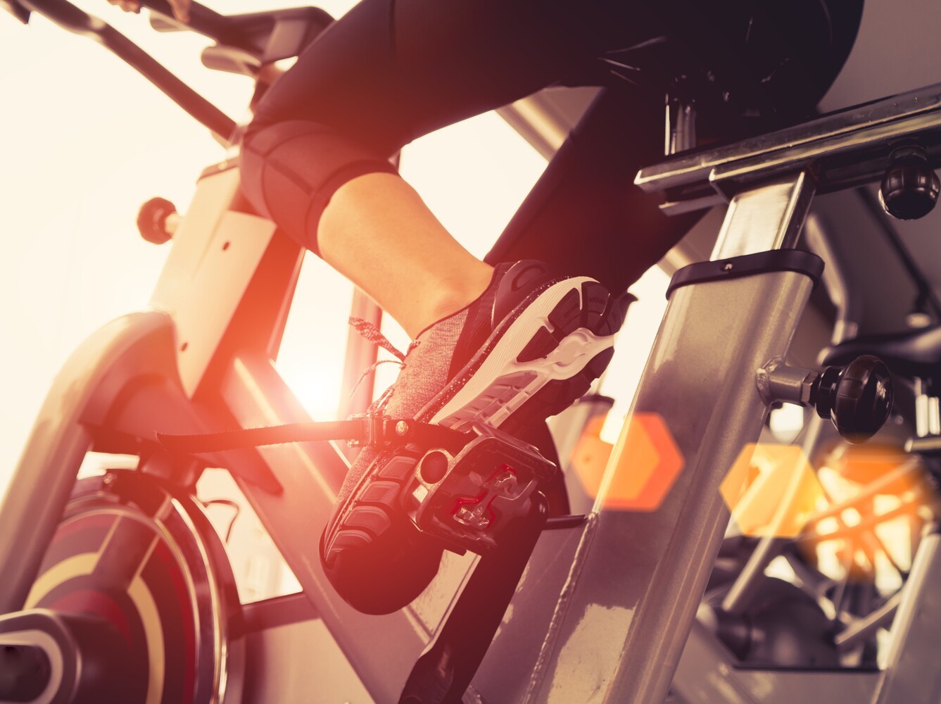 woman cycling in gym to compare it to walking time for weight loss