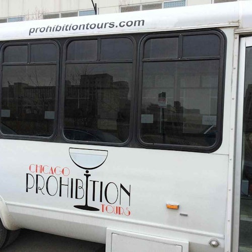 一輛有「芝加哥禁酒之旅」和馬提尼酒杯圖案的巴士，停在都市區域。