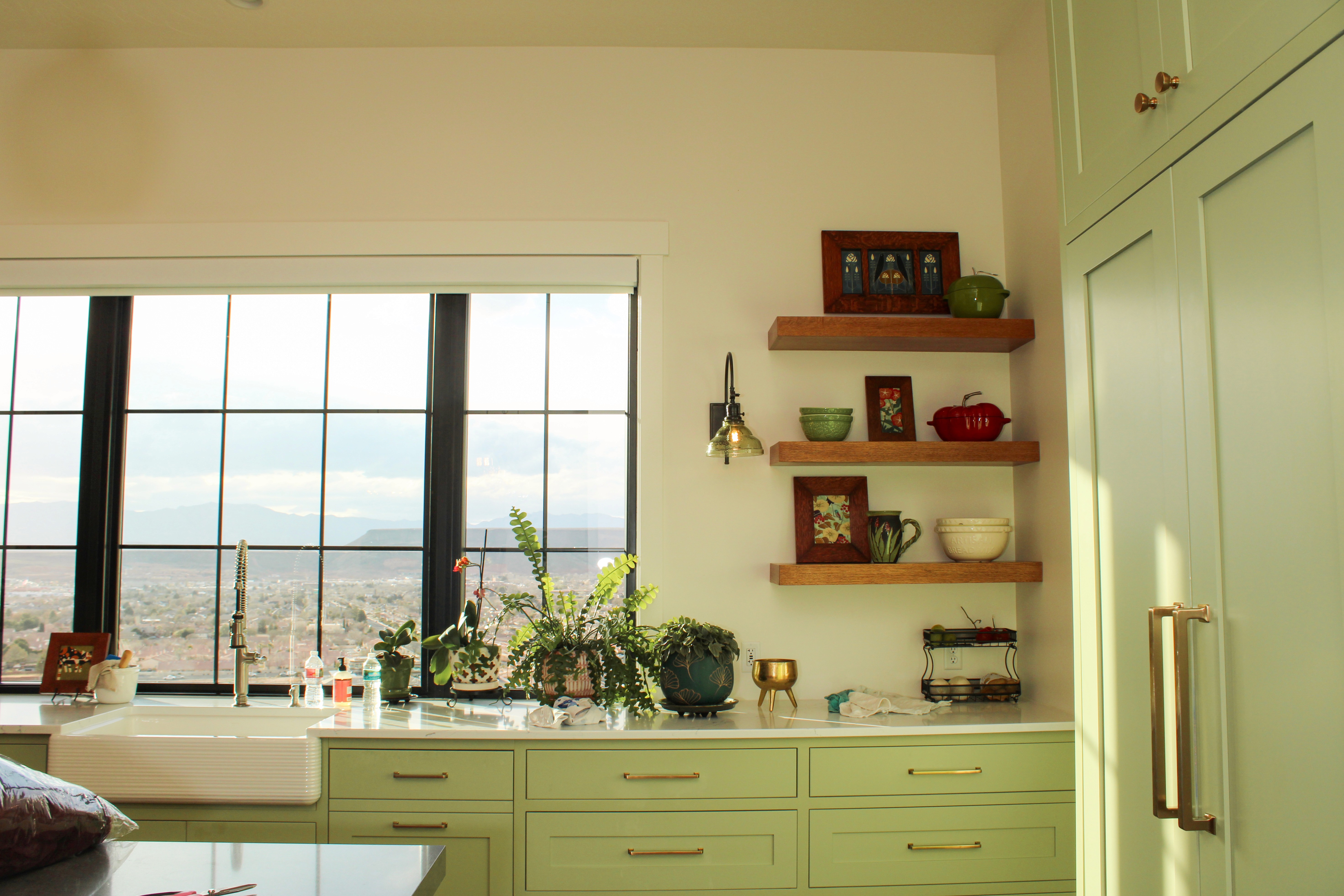 Kitchen in St. George Utah remodel with green cabinetry and natural wood open shelves by Madsen Homes