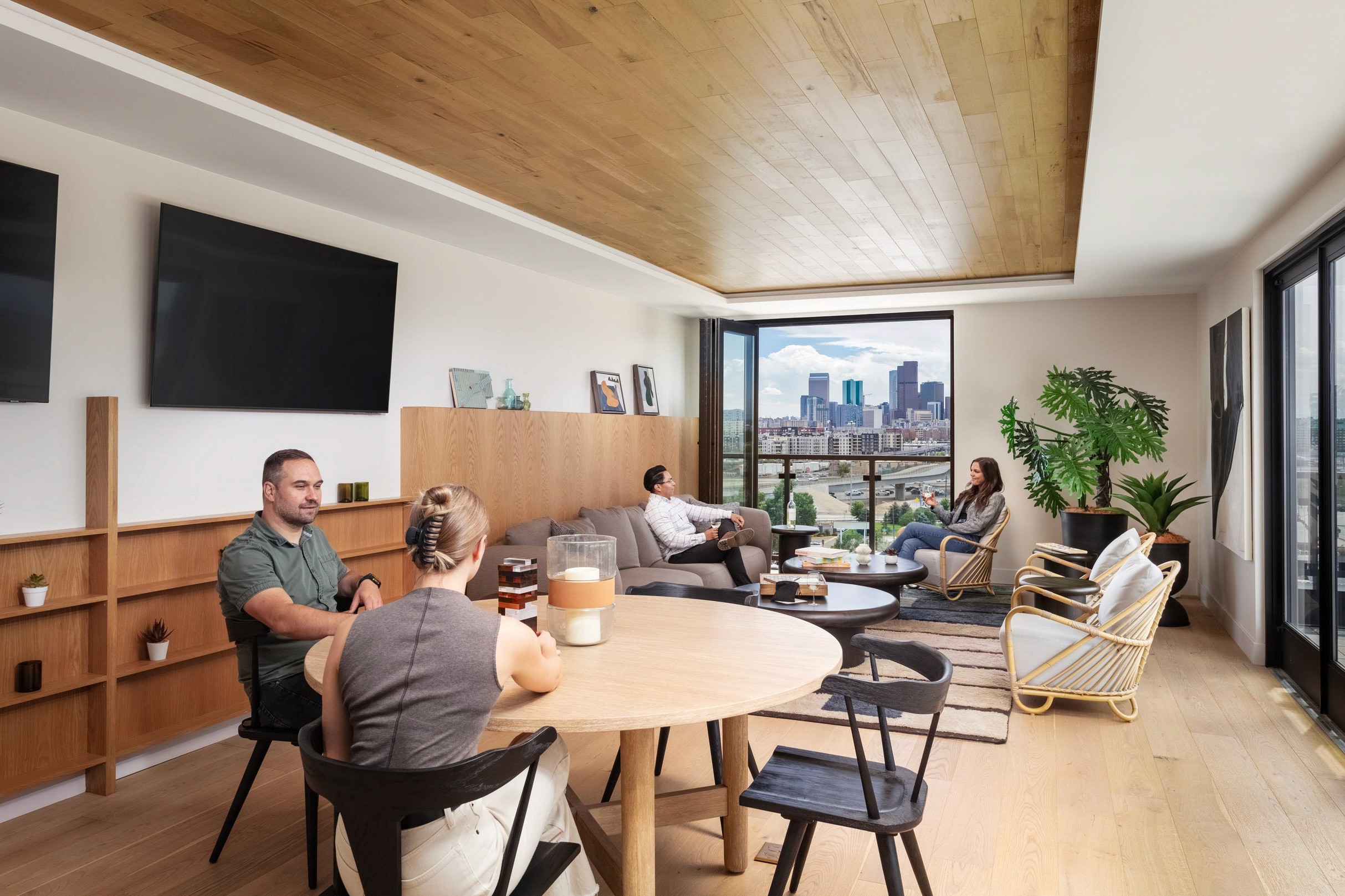 People in a modern living room with city view.