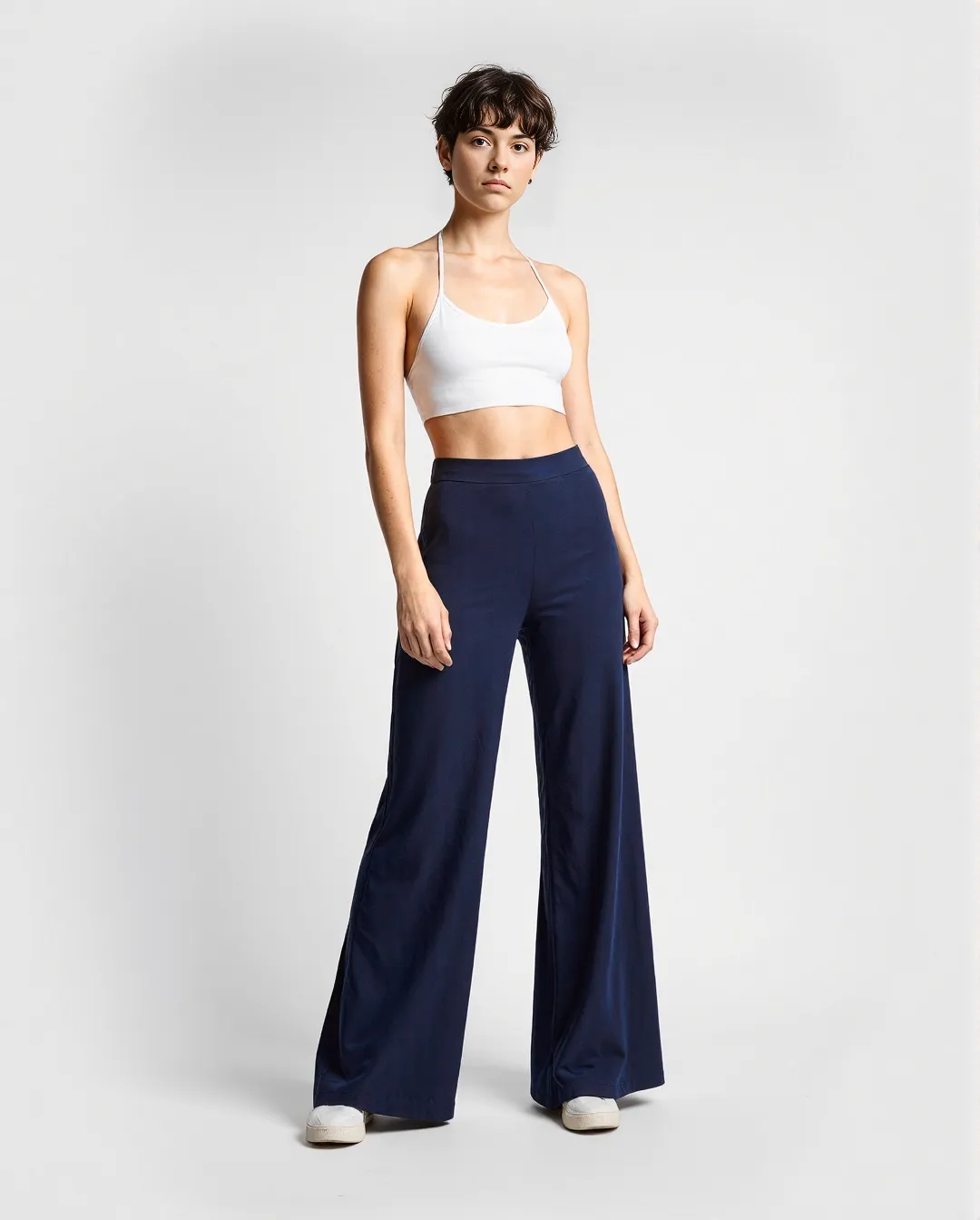 Fashion photography featuring navy wide-leg pants paired with white halter crop top against clean white background in minimalist style