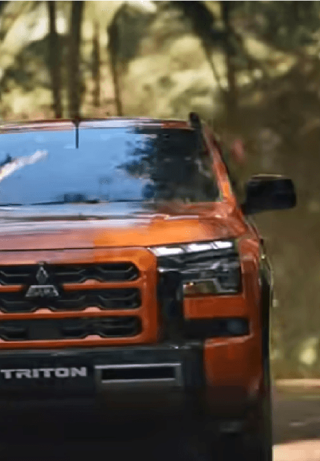 Orange car with black details out in the woods 