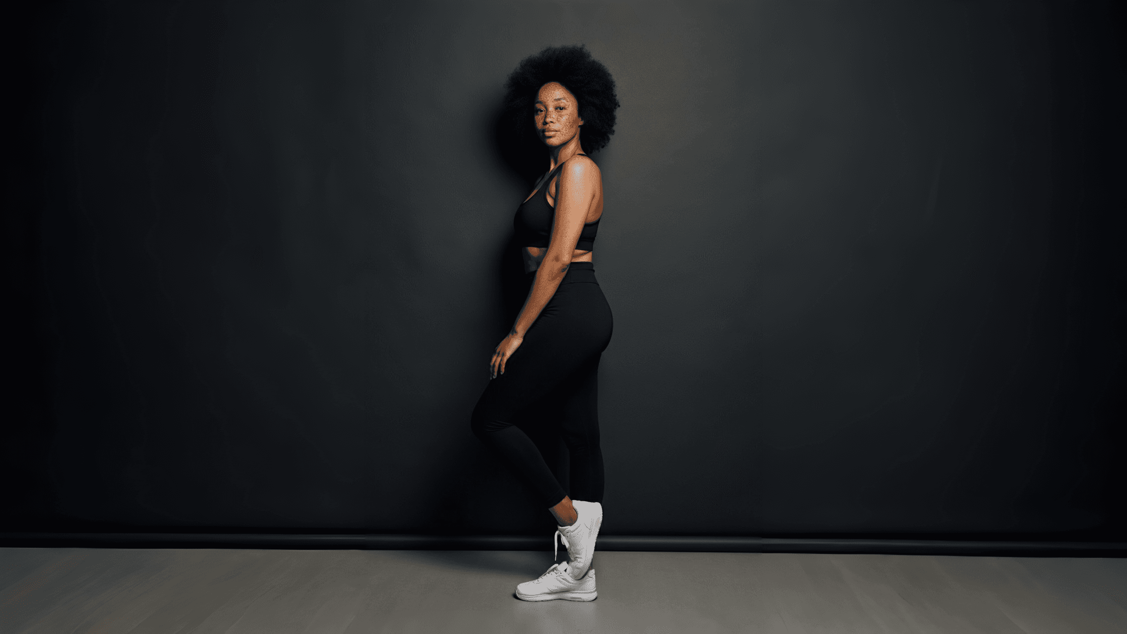 Woman posing in a black sports outfit.