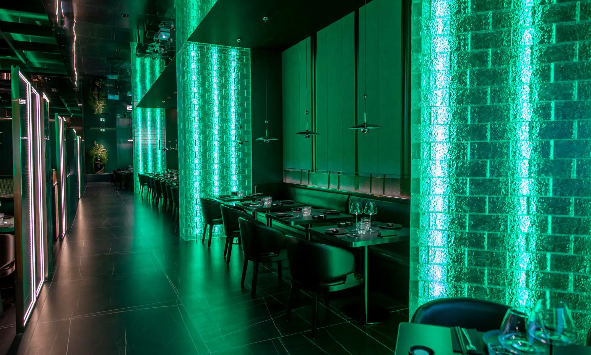 Sushi Club Avignon dining room, glowing glass-brick columns and emerald walls