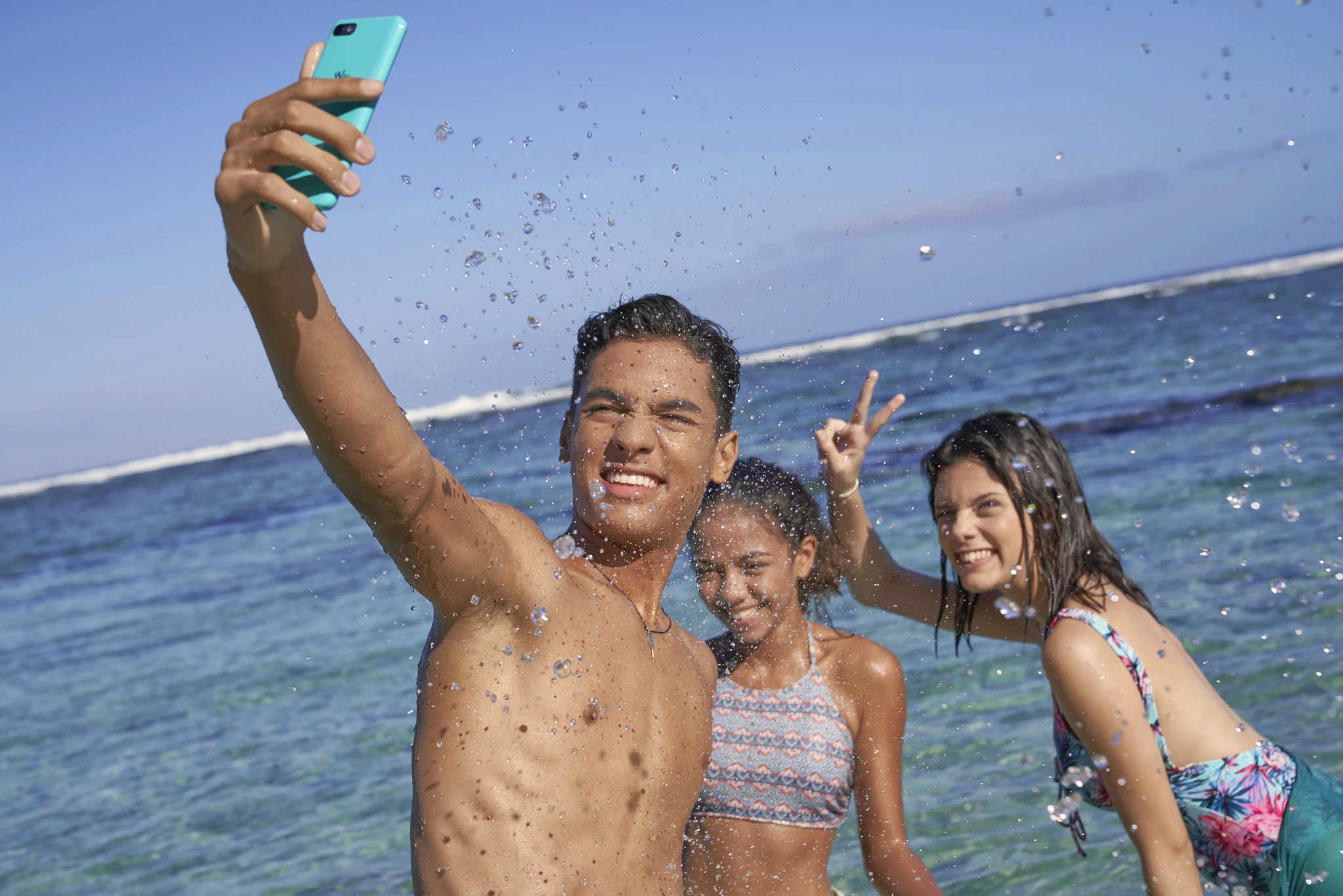 Production visuelle lifestyle : jeunes prenant un selfie dans le lagon de La Réunion, campagne publicitaire dynamique et solaire — David Dijoux