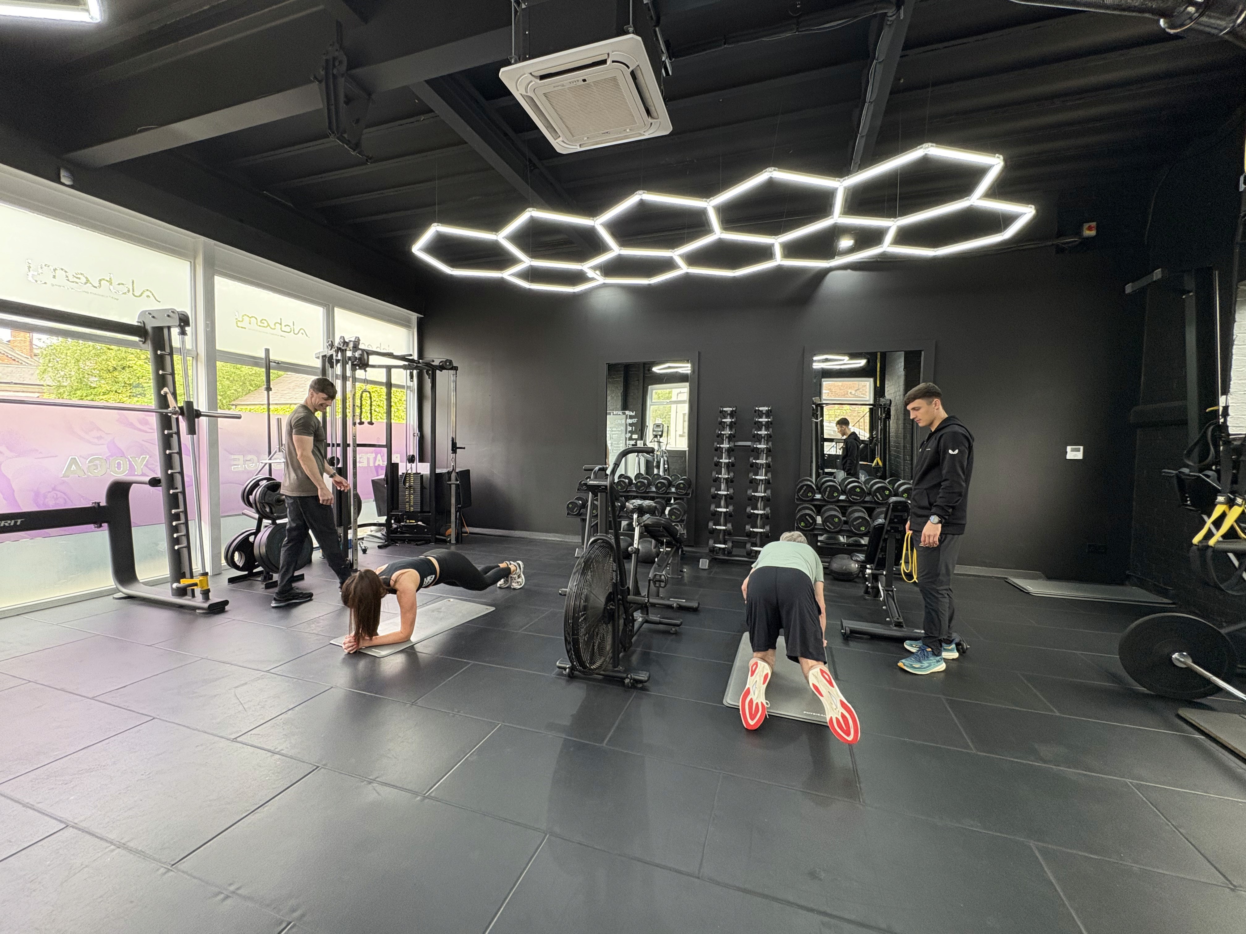 Personal trainers in Wilmslow leading small group training sessions with individualized attention in a modern, private gym.