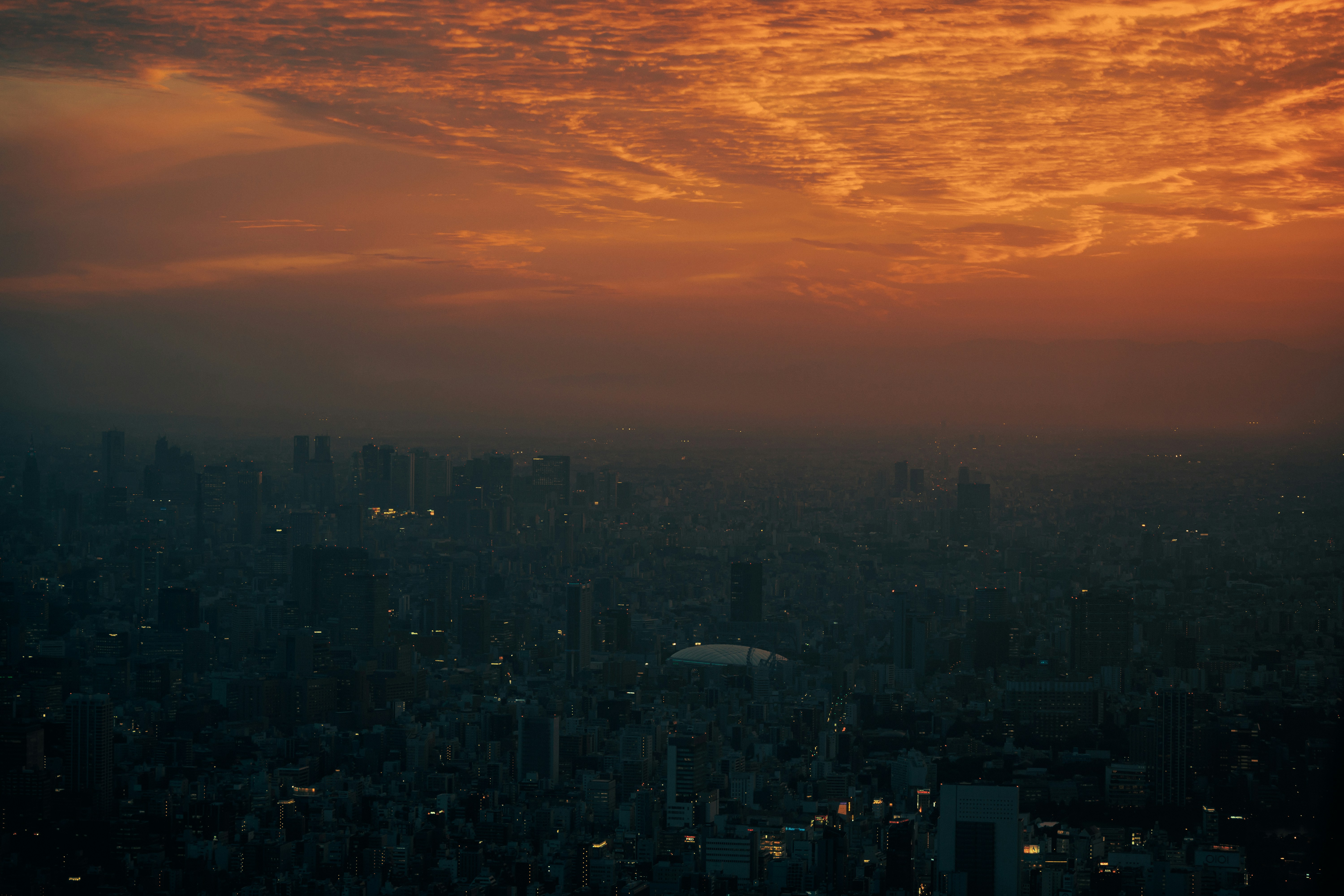 A view of a city at sunset from the top of a building