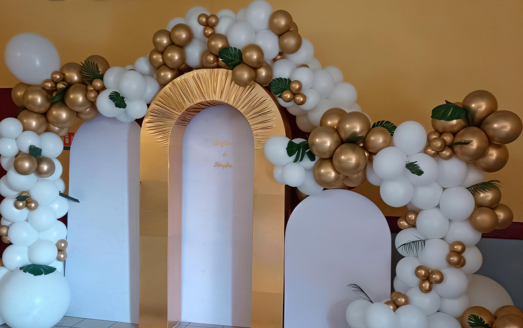 Grande structure composé d'une arche organique en blanc et doré, agrémenté de feuilles, réalisé à l'occasoin d'un baptême