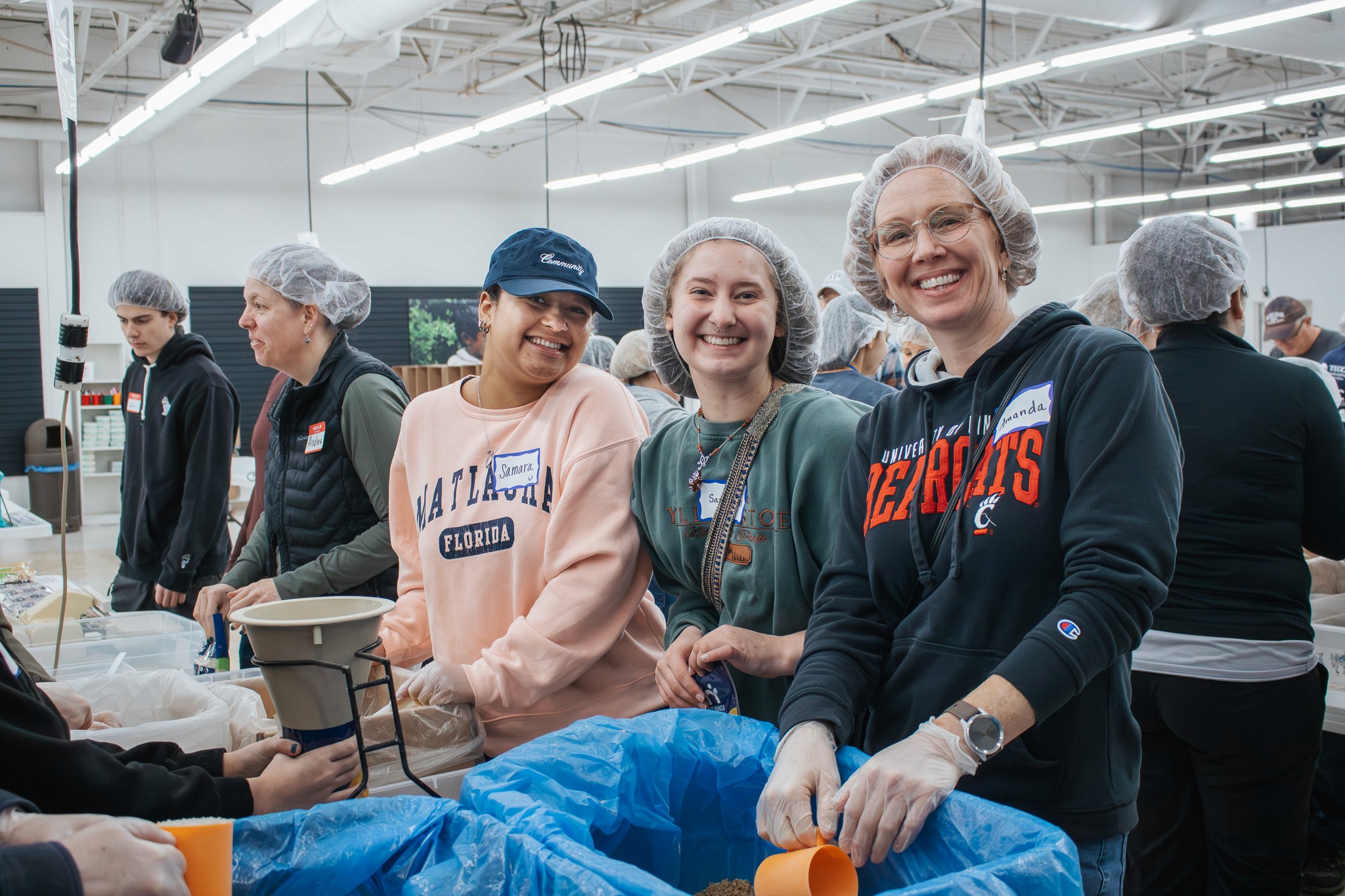 Smiling young girls embrace and laugh together outdoors, reflecting the joy and community fostered by faith-based care.