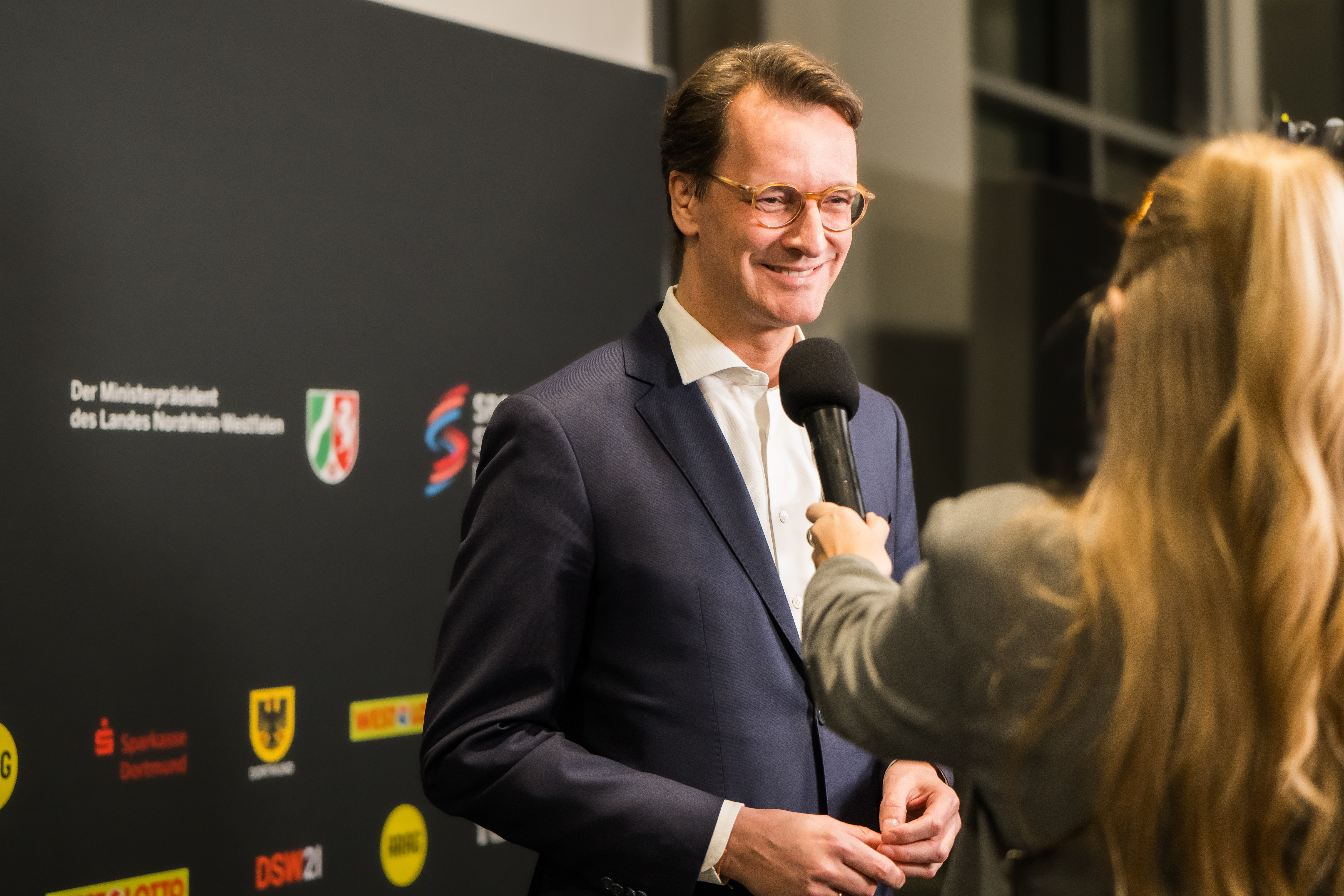 Politiker Hendrik Wüst lächelnd im Interview