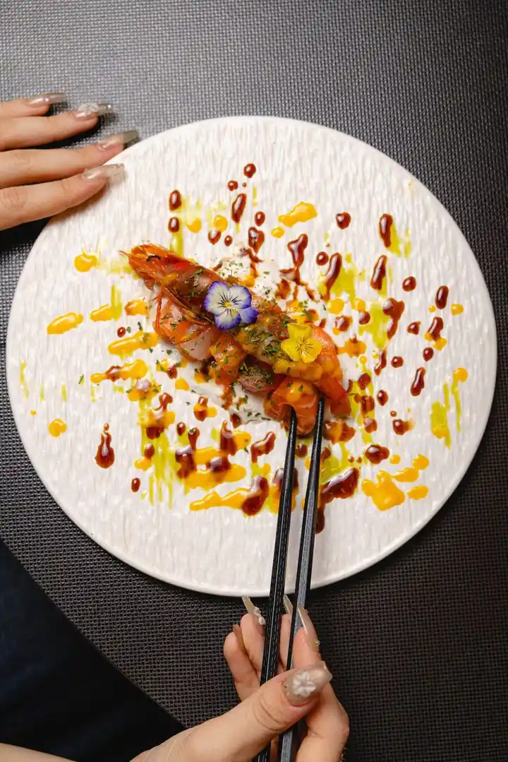 Signature creation plated on a white plate, with dots of colourful sauce