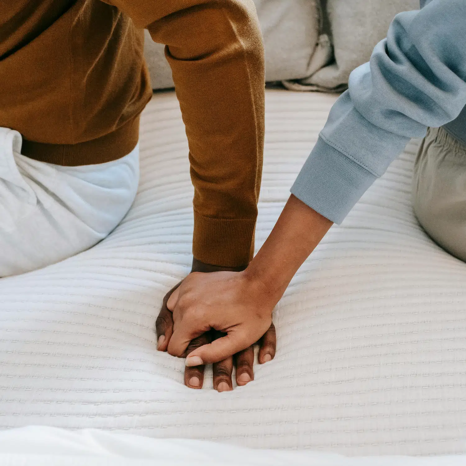 Close-up of couple holding hands during LGBTQ codependency therapy session, symbolizing emotional support and relationship healing in Los Angeles.