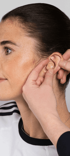 A close-up of a person with a side profile, someone adjusting their earring.