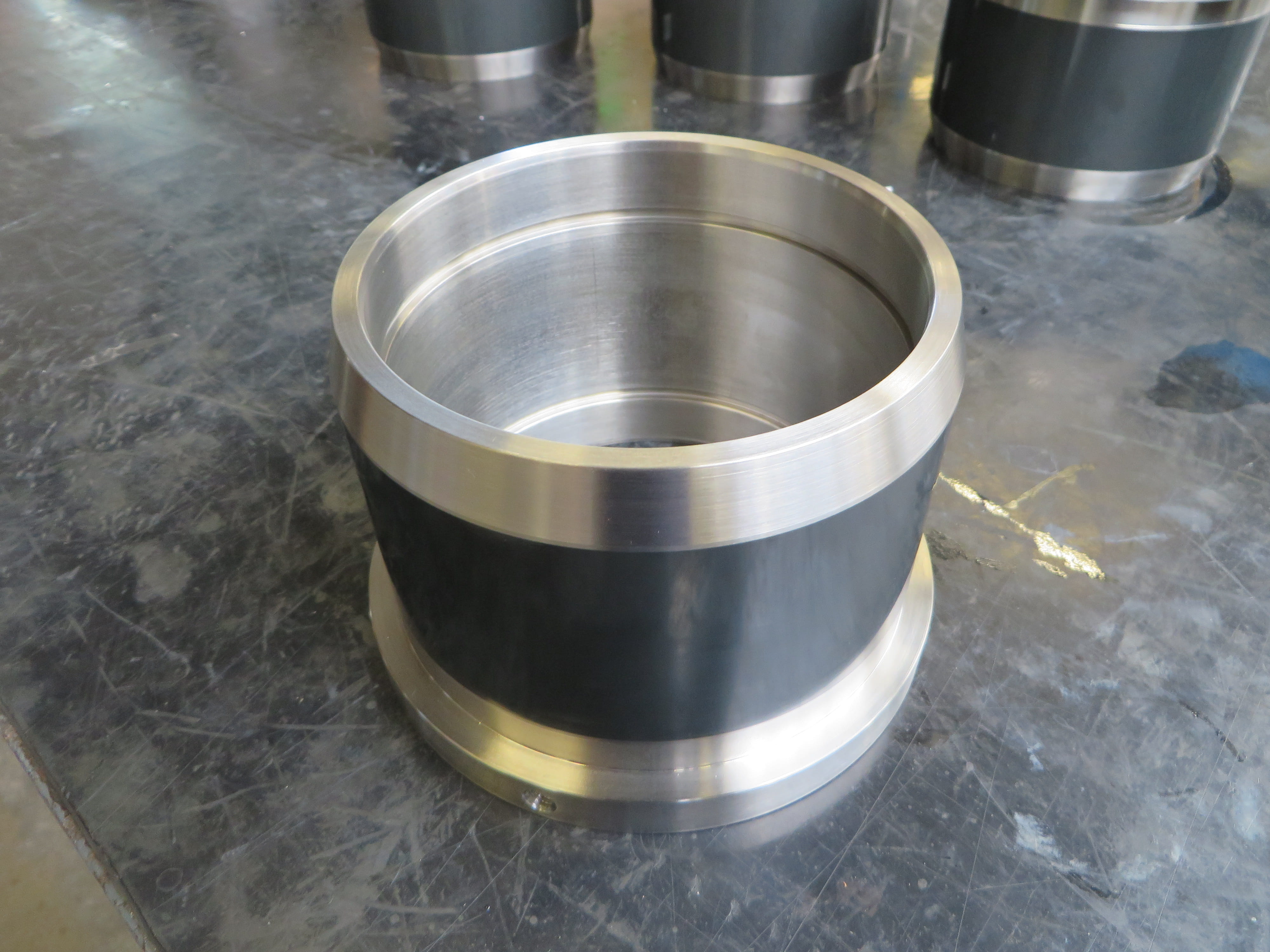 Cilindrische metalen bus met thermisch gespoten coating voor slijtagebescherming