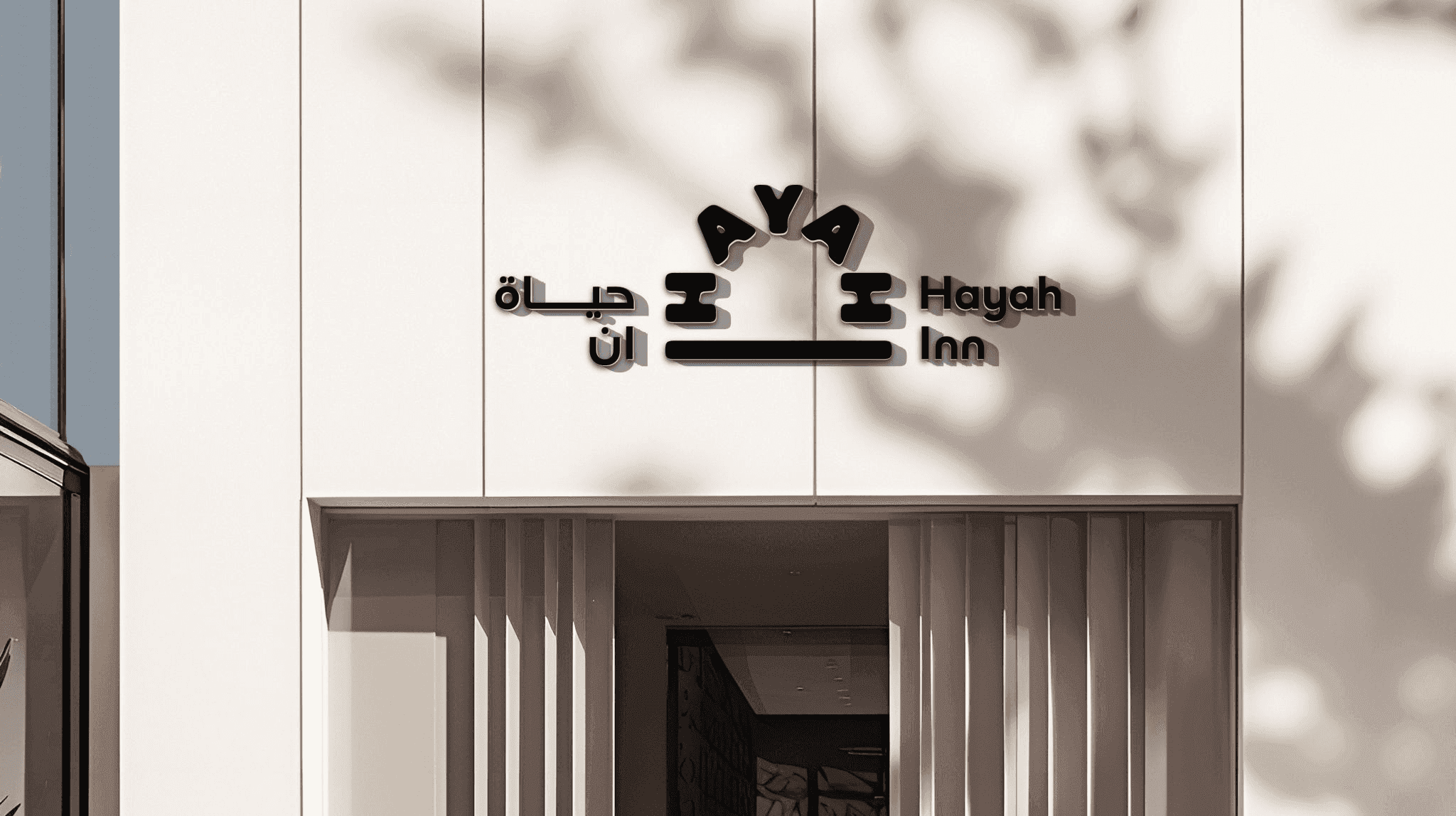 Hayah Inn bilingual signage above a building entrance.