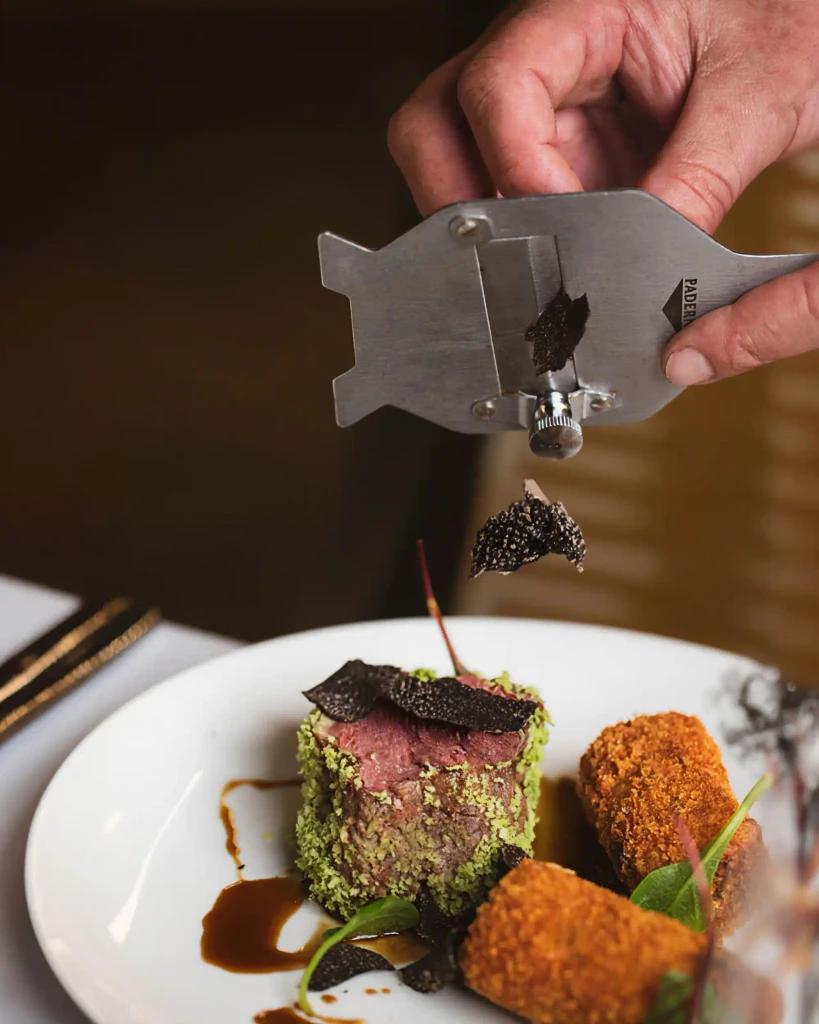 Close-up of a restaurant menu, featuring the name "Verpan's" in elegant script. A butter knife rests on a small plate next to the menu.