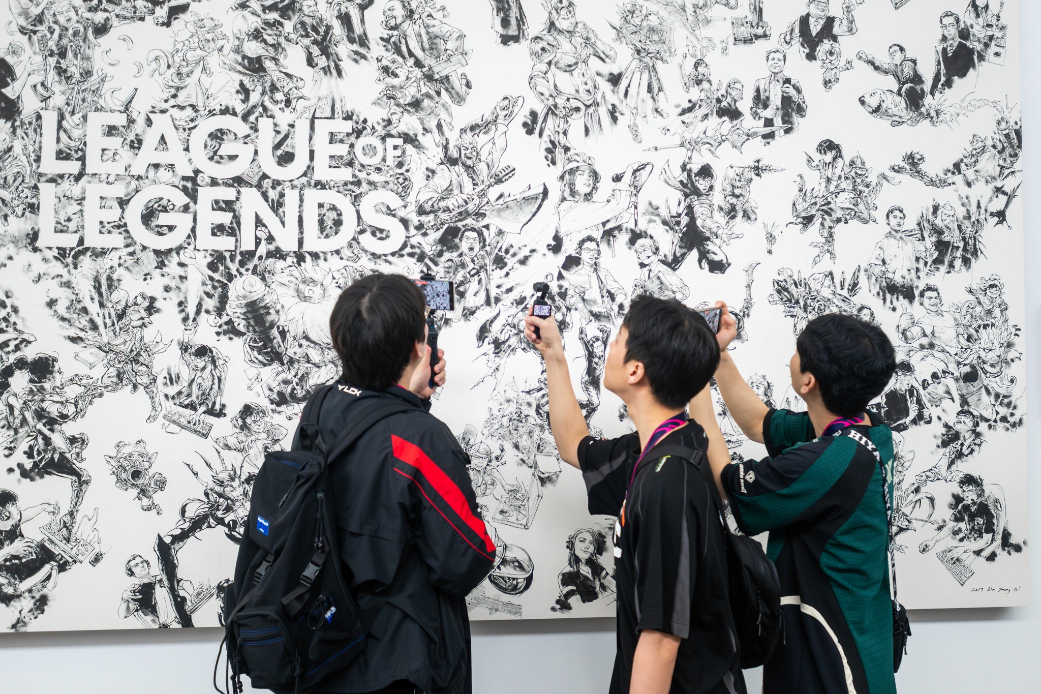 A group of attendees listening intently to a speaker at the League of Legends event.