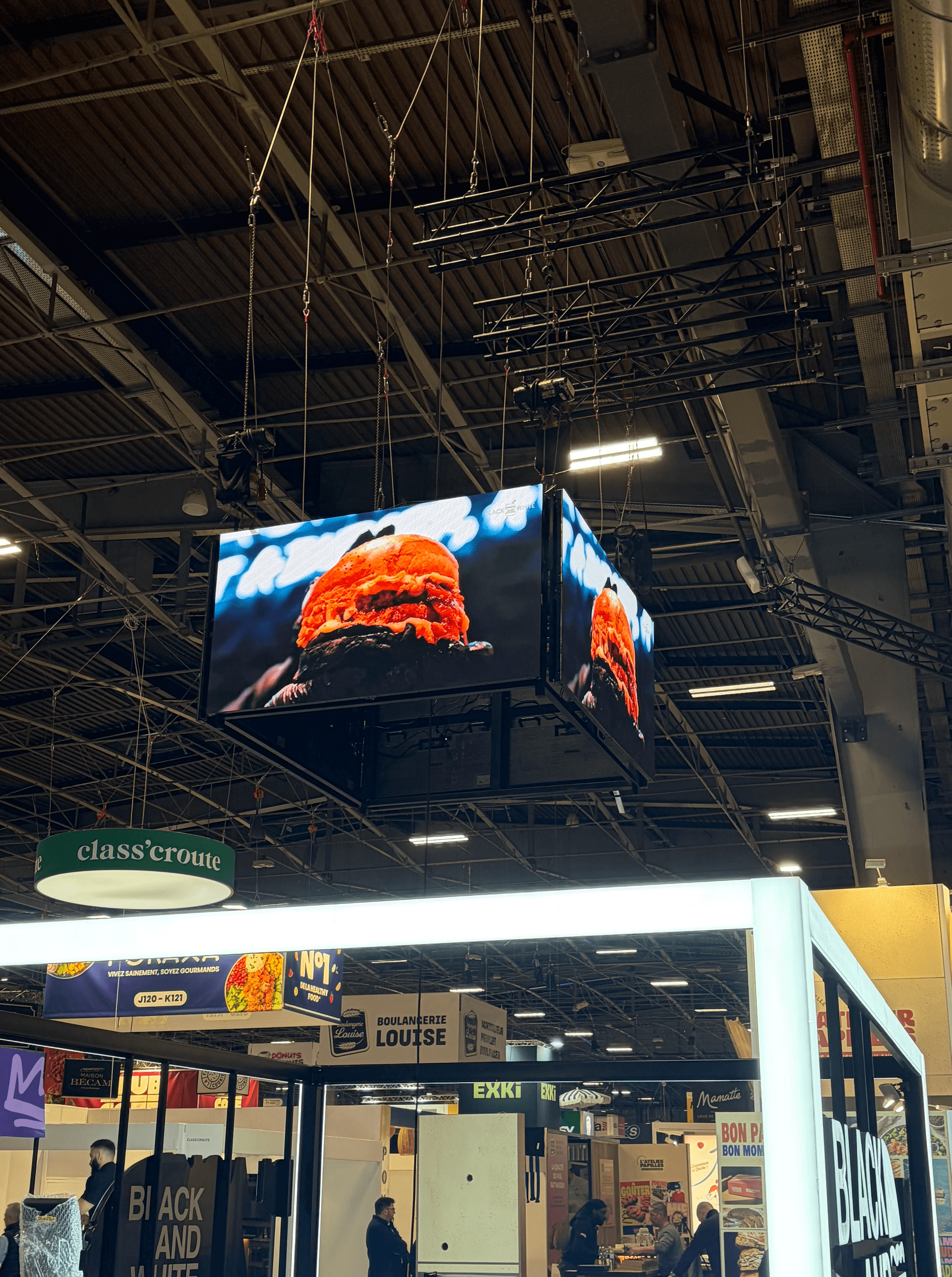 A talent recruiter with a soft smile working on her laptop in the office. The angle is on her face so we can't see what's is on the screen. She is wearing a blazer 