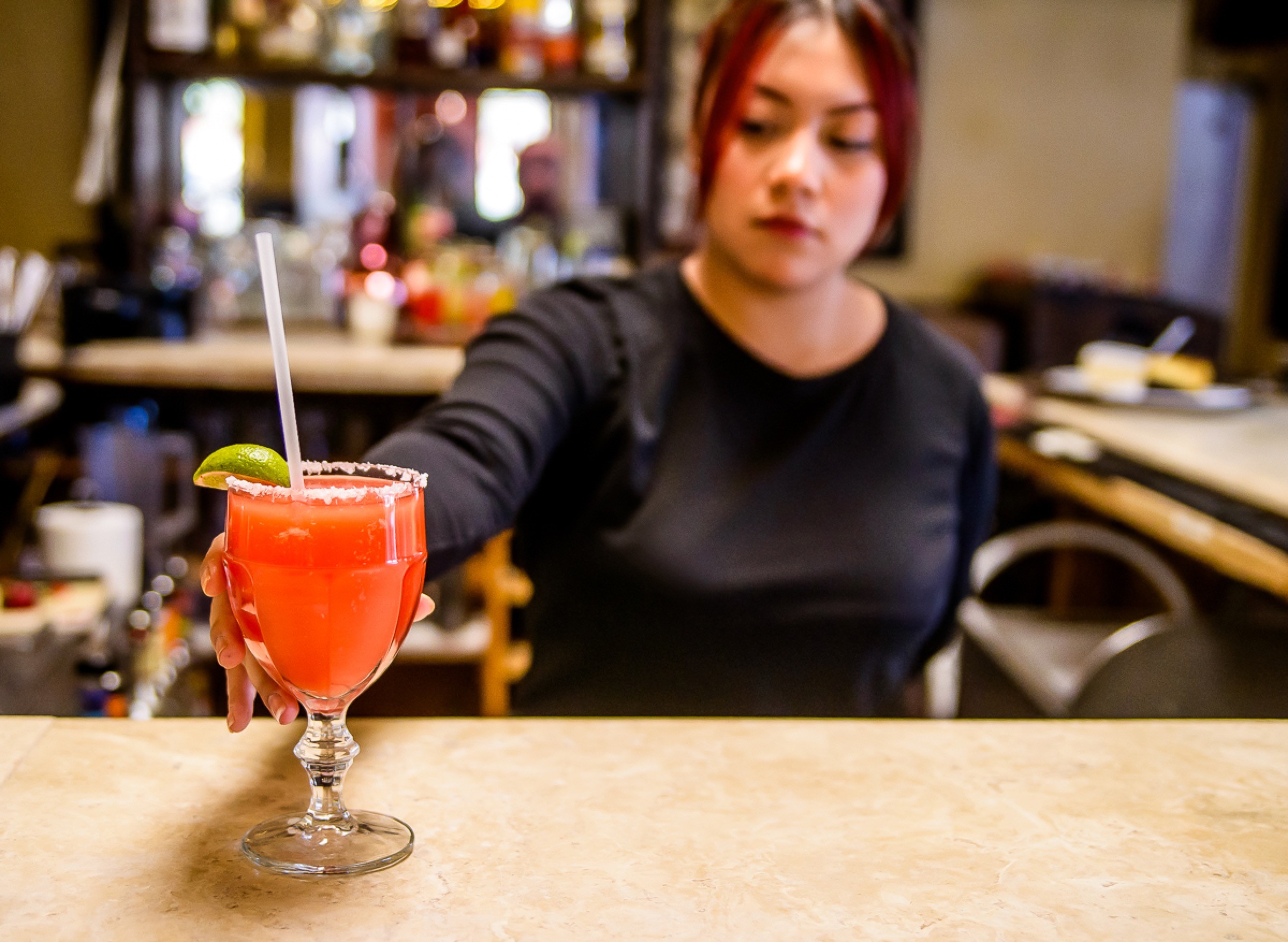 Bartender presenting a bright cocktail