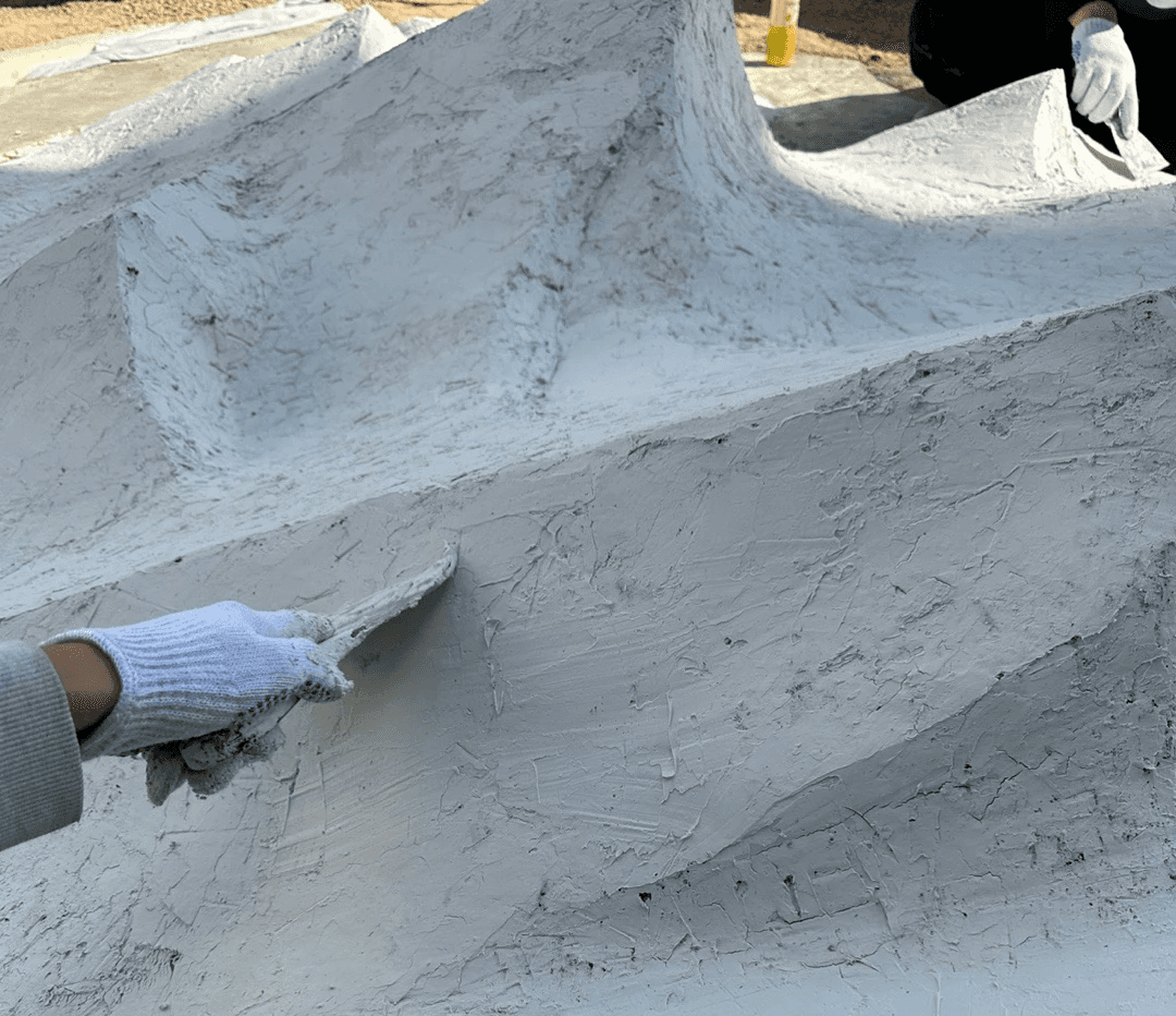 시멘트 마감 후 산맥 조형물 표면 디테일, 손 작업 텍스처 / Close-up surface detail of the cement-finished mountain sculpture texture
