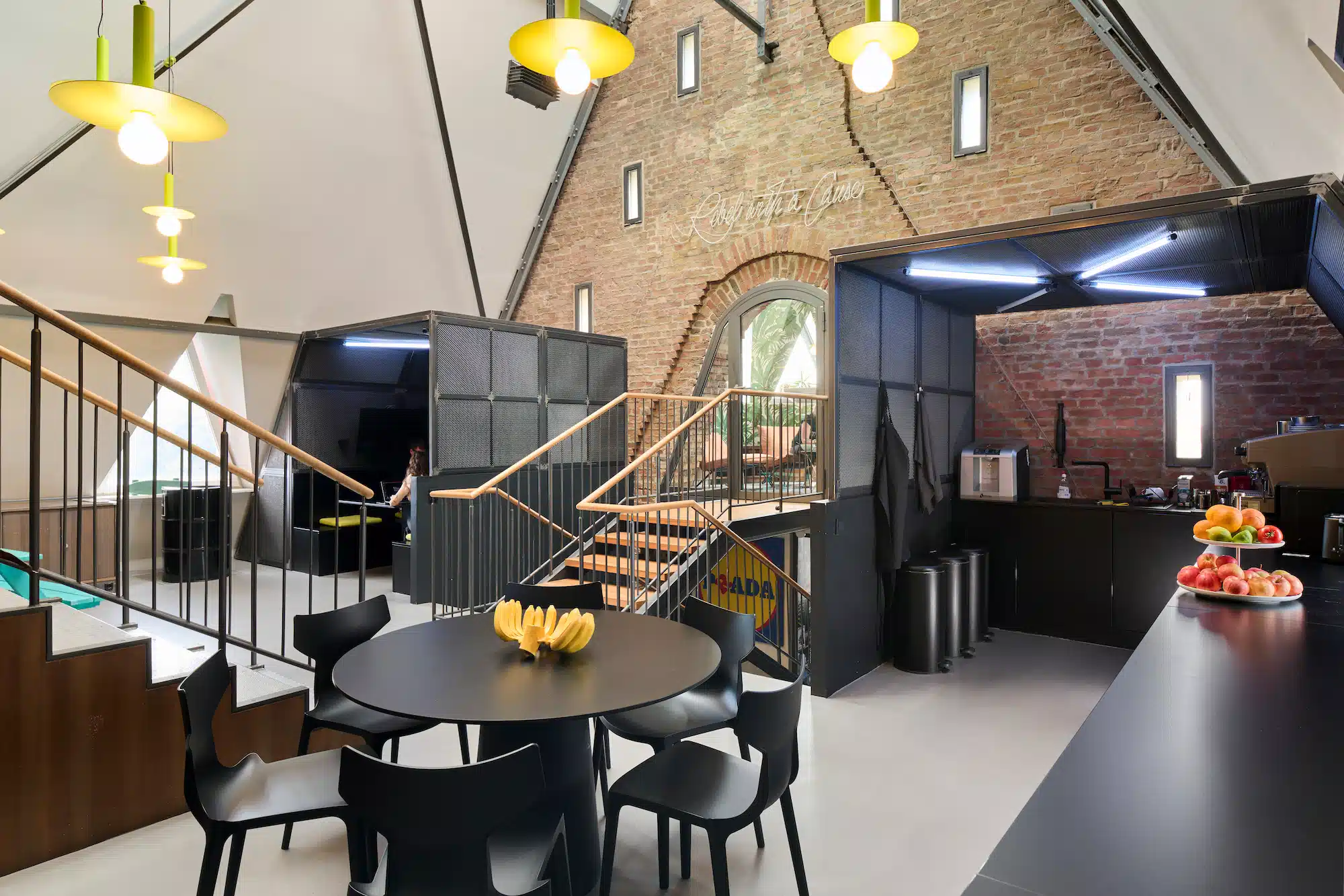 Dojo Office – full overview of the office with double staircase, kitchen bar, fruit decoration and brick vault