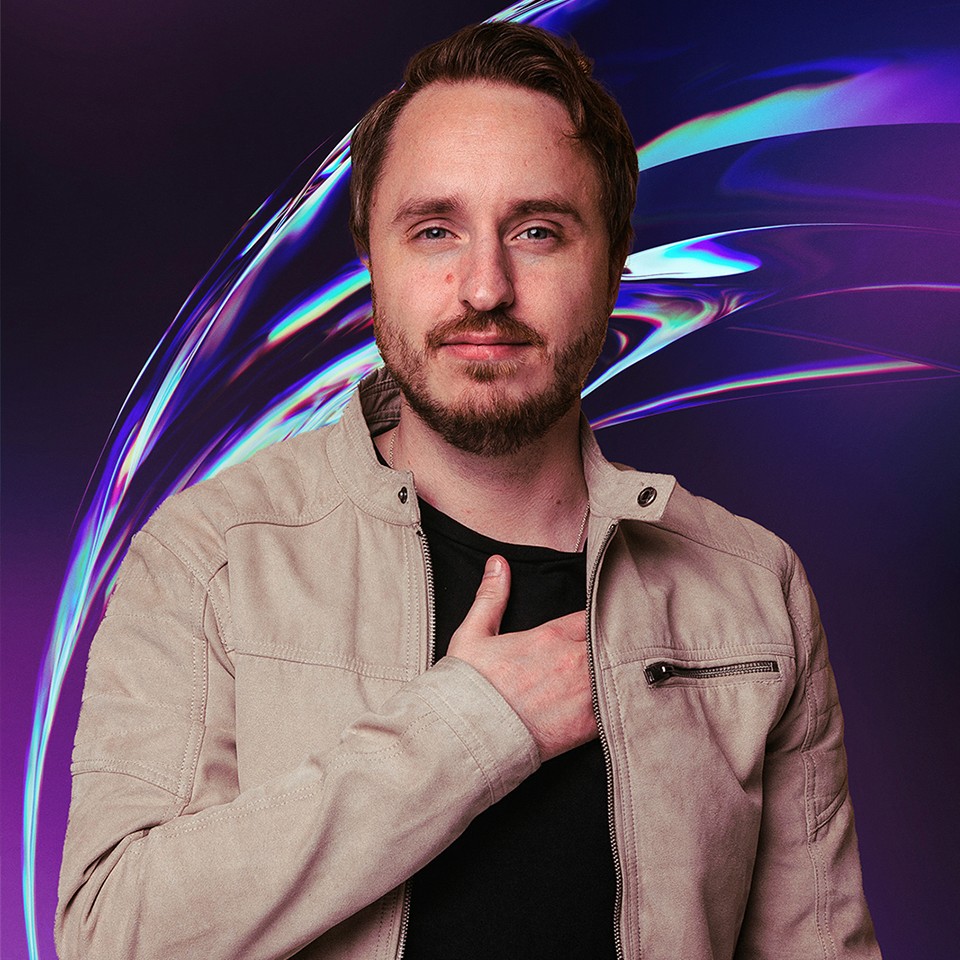 Portrait of a young man with short hair, wearing a dark t-shirt, against a plain background.