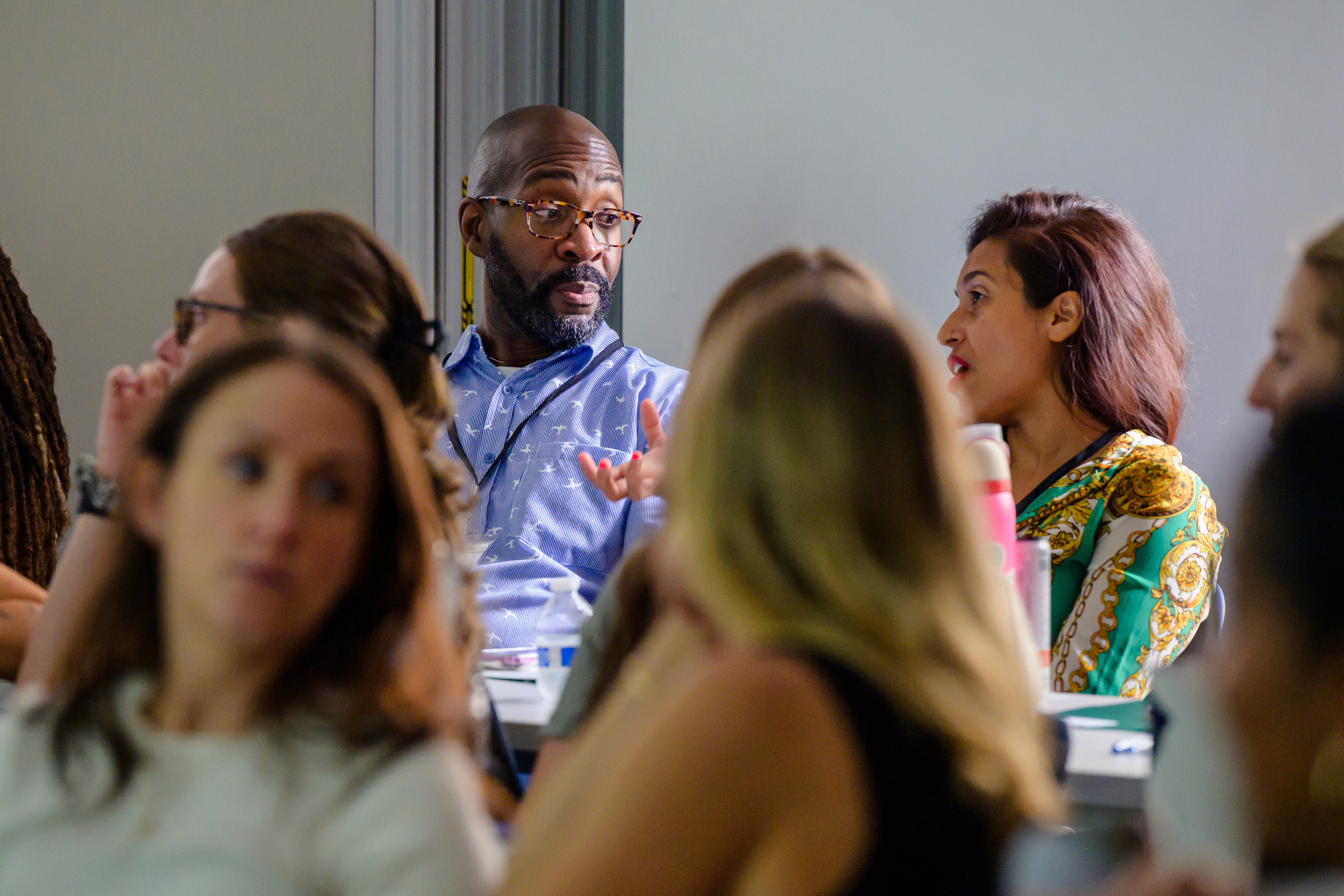 Photo of Teaching Lab Studio member at workshop chatting with other member.