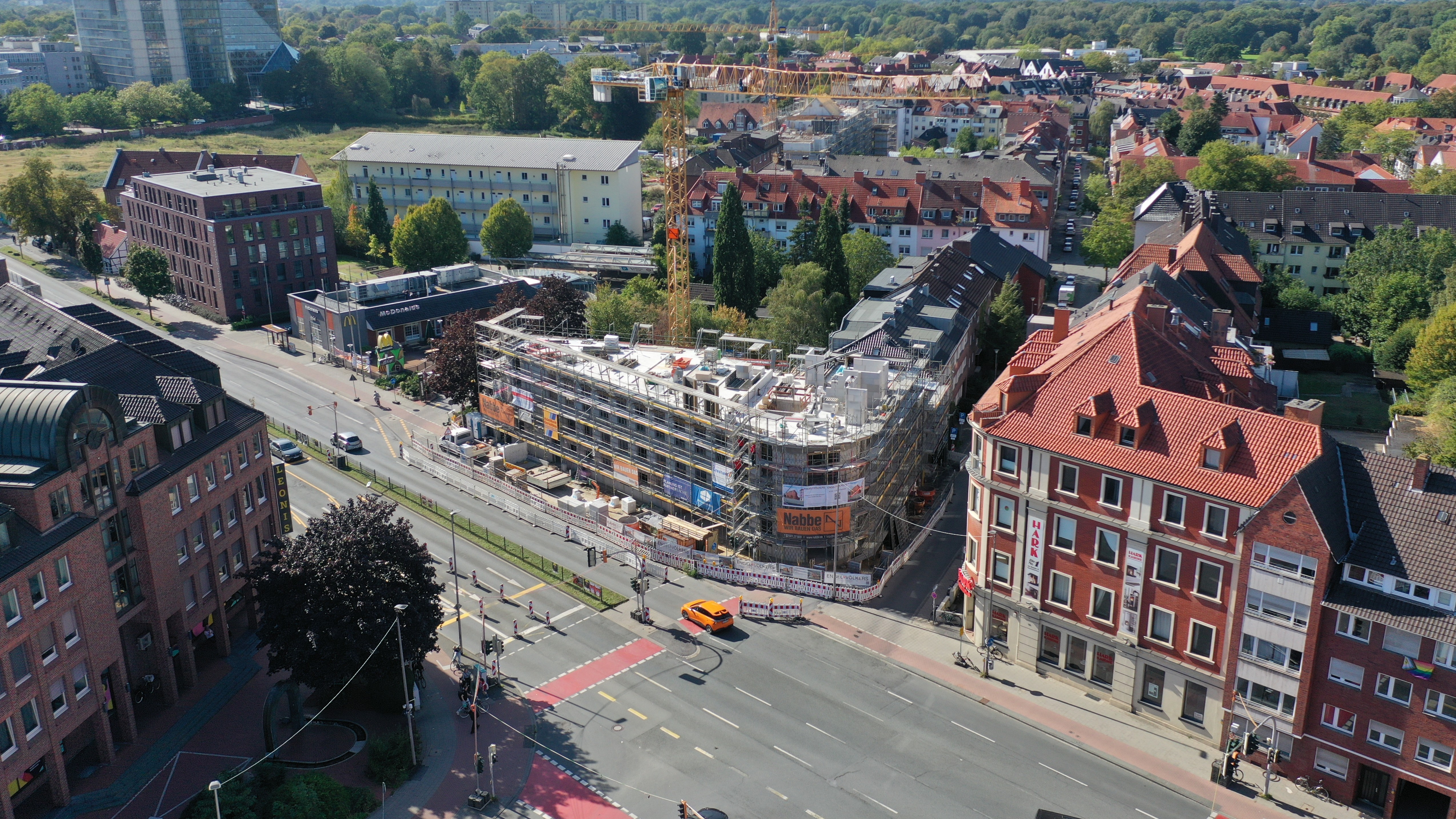 Isometrische Zeichnung eines Bauprojekts mit mehreren Gebäuden und markierten Strukturen in Rot